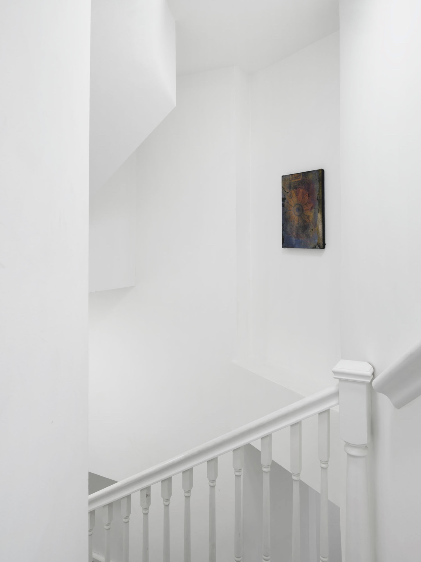 What You See is Not Here Tomorrow by Radek Brousil at Krupa Gallery — A stairwell passage in Krupa Gallery's London venue features a small framed artwork mounted on white plaster wall at mid-height.