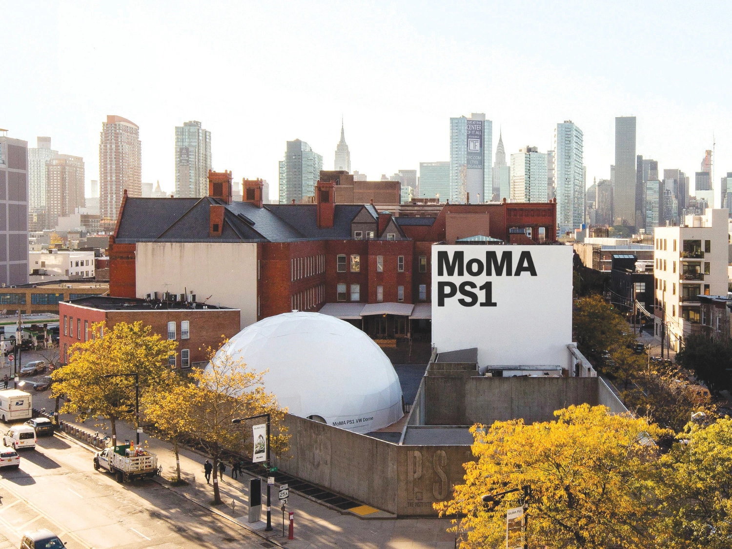 MoMA PS1 Entrance Building by Andrew Berman Architect — Aerial view of MoMA PS1's entrance pavilion reveals the monolithic cast concrete structure anchoring a densely built Long Island City block.