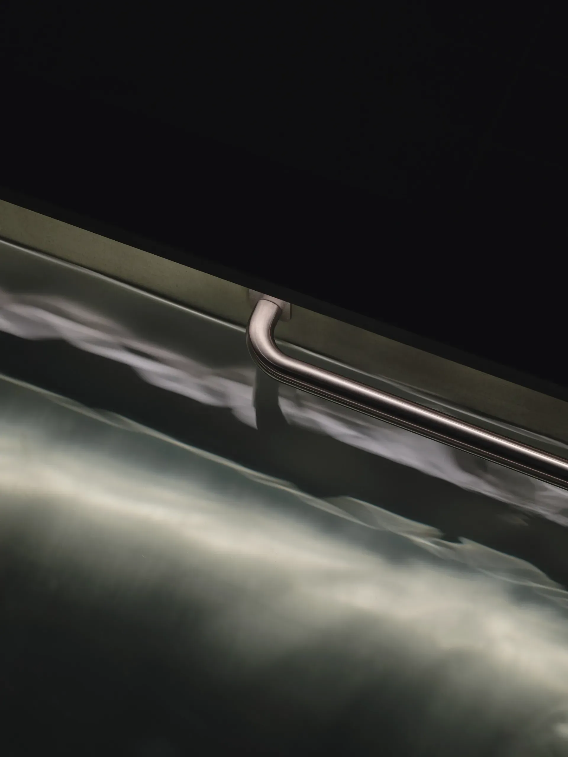 Arc Canary Wharf by Cake Architecture — A close-up detail of Arc's signature curved handle mounted on the upper rail of the tiered seating.
