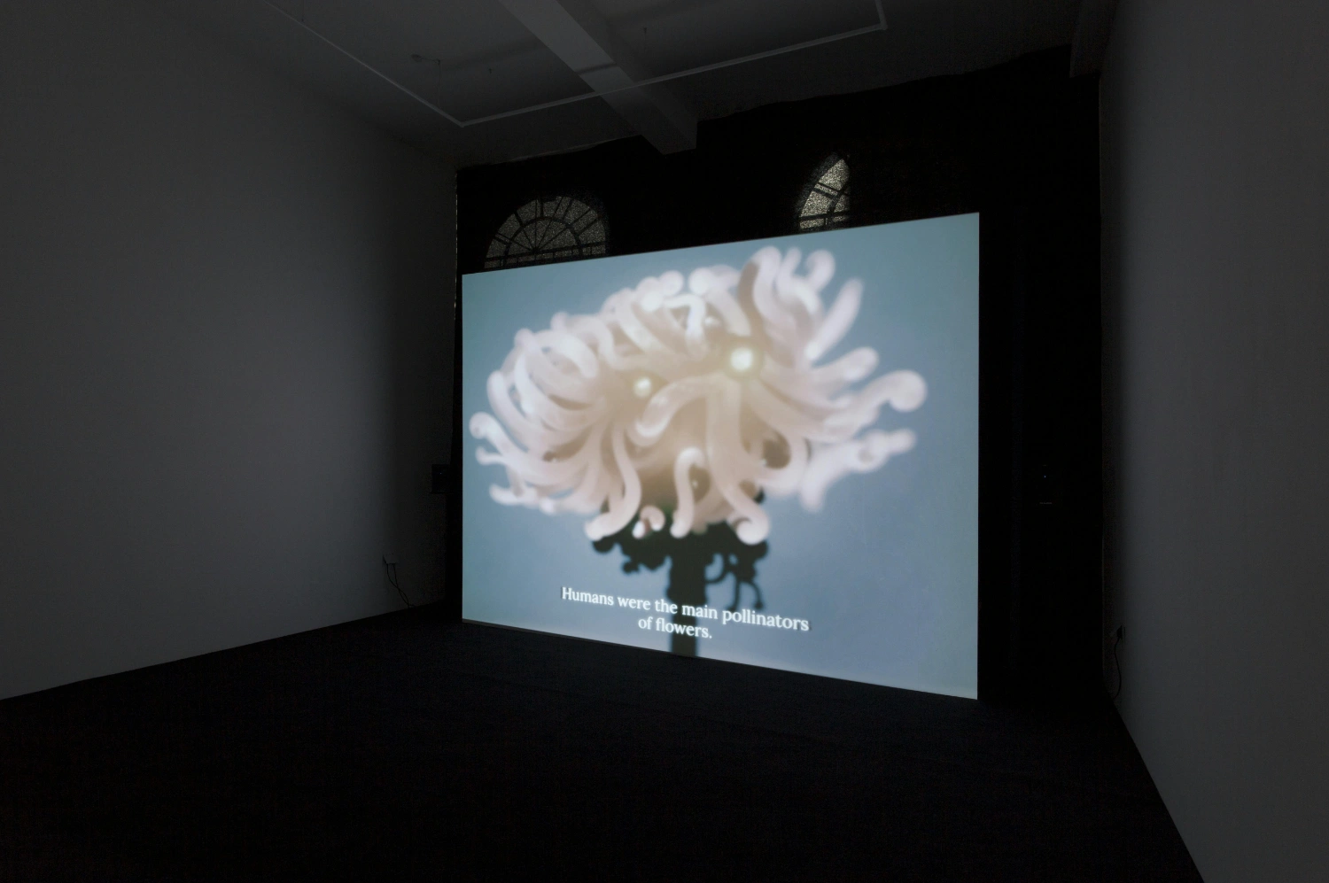 The Book of Flowers by Agnieszka Polska at Union Pacific — A large-scale projection displays a digitally rendered white flower with symmetrically radiating petals against a pale blue gradient background.