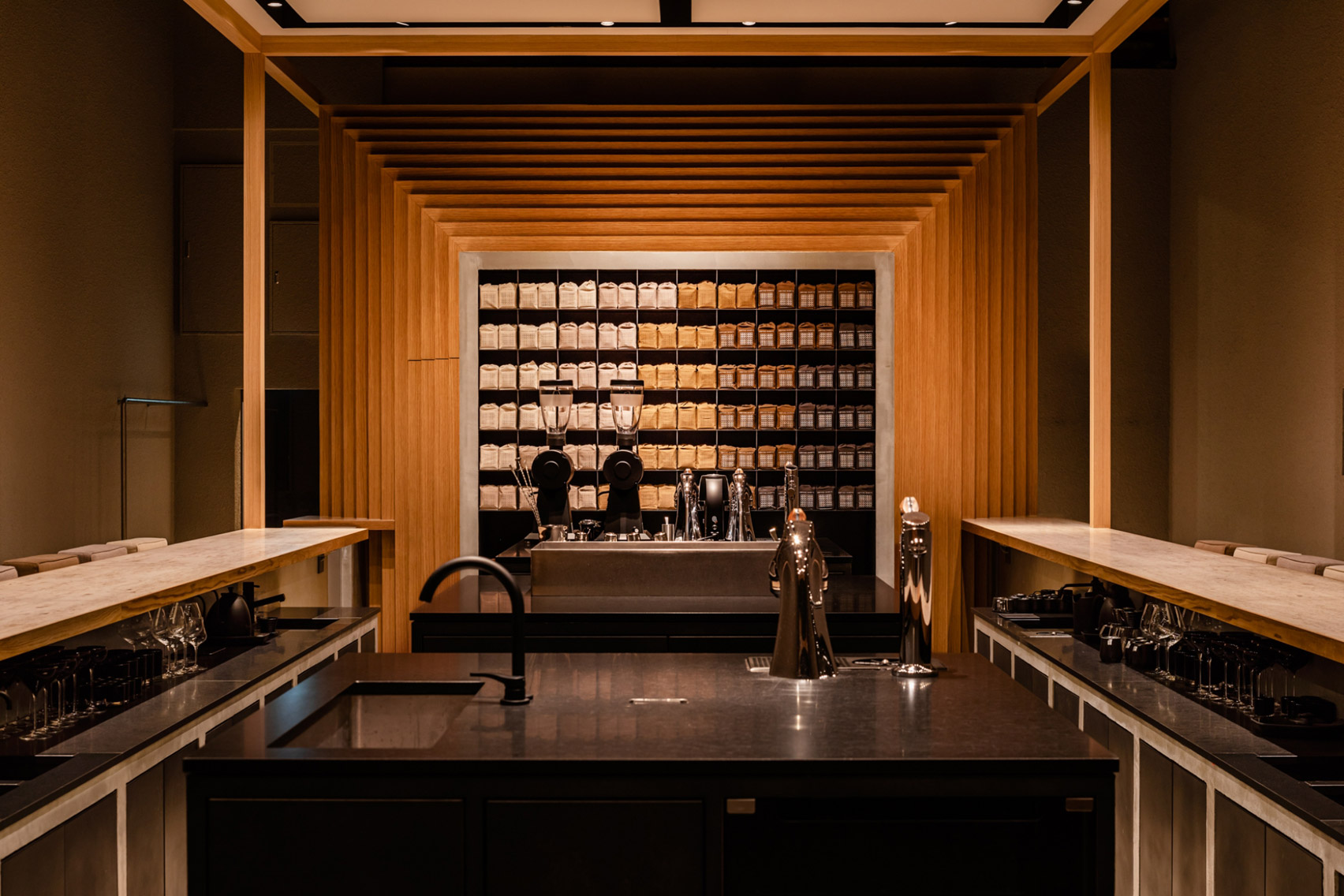 Koffee Mameya Kakeru by Fourteen Stones Design — The interior of Koffee Mameya Kakeru unfolds as a symmetrical composition framed through floor-to-ceiling glass.