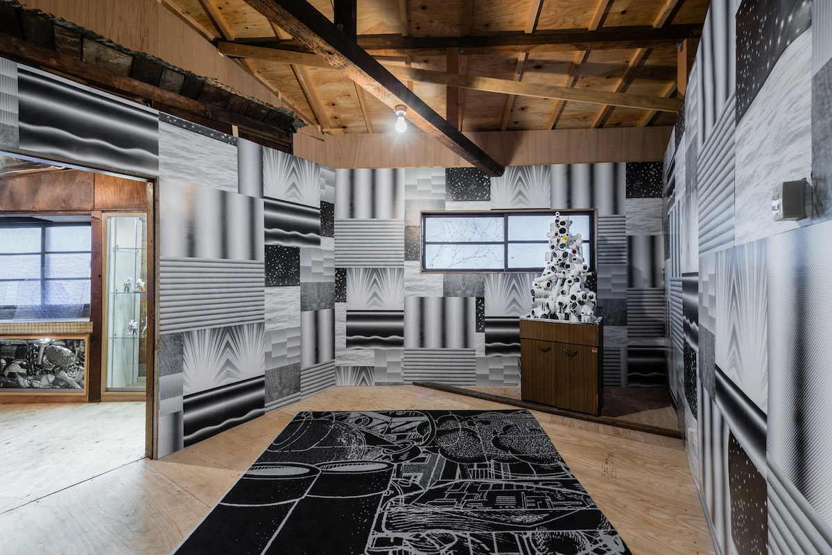 Chidori-Bunka by Dot Architects — A showroom interior displaying ceramic tile samples arranged in a dense grid across walls in black, white, grey, and patterned finishes.