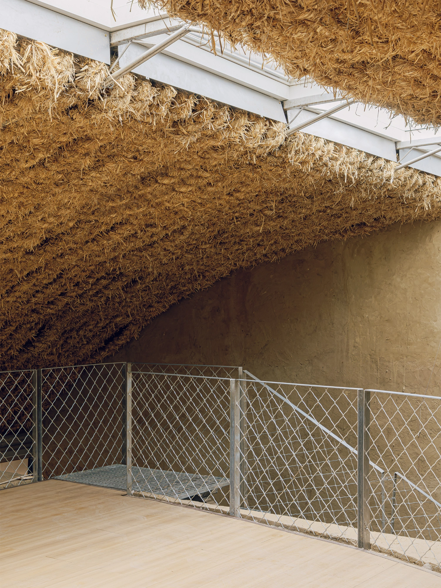 Home in the Badain Jaran Desert by School of Architecture and Urban Planning NJU — A generous interior volume defined by straw-brick walls rising to full height, creating a monolithic enclosure.
