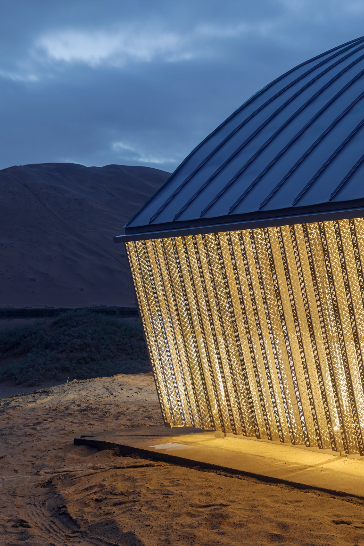 Home in the Badain Jaran Desert by School of Architecture and Urban Planning NJU — Twilight photograph capturing the eastern facade of the desert dwelling at dusk.