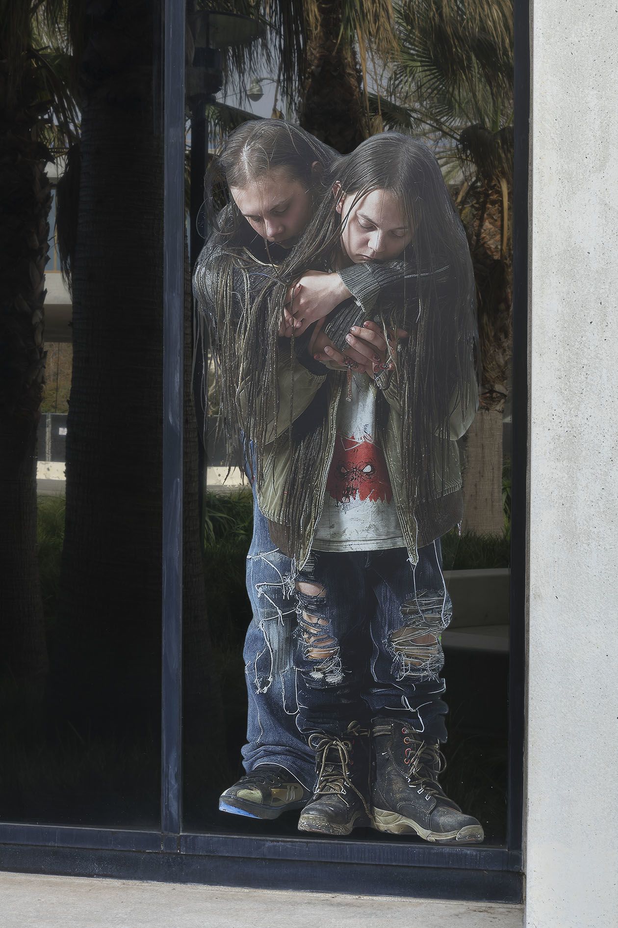 Proof of Concept by Jon Rafman at Sprüth Magers LA — Two figures peer through a glass storefront entrance, framed within the threshold of Sprüth Magers LA.