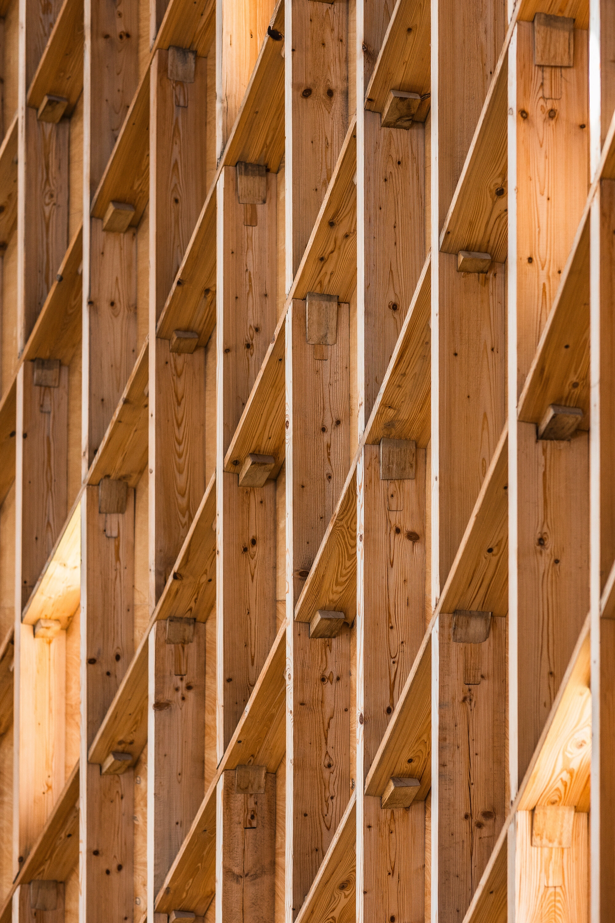 Our Lady of Sorrows Chapel by RCNKSK — Close-up view of the chapel's interior timber structure revealing the post-and-beam construction system.