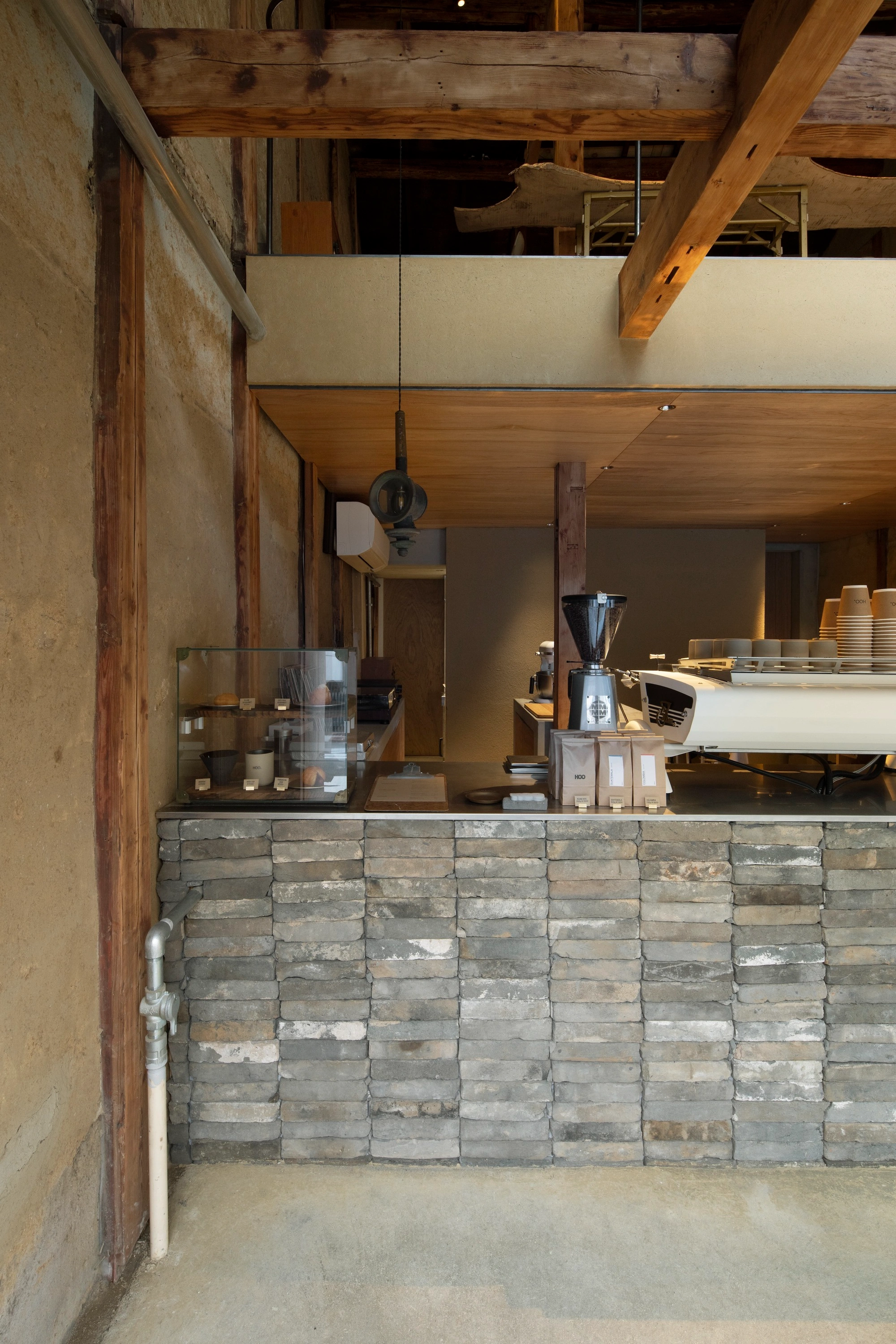 HOO Cafe Kyoto by Koyori Architects — Interior view of HOO Cafe's service counter, revealing the adaptive reuse strategy at the threshold between street and interior.