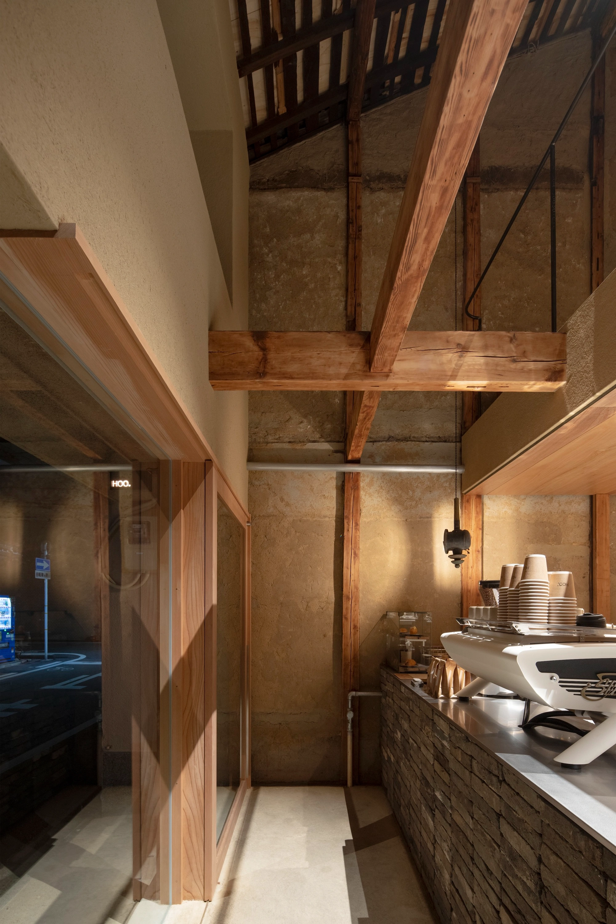 HOO Cafe Kyoto by Koyori Architects — Interior view of HOO Cafe's narrow kitchen passage, revealing the adaptive reuse strategy through contrasting material palettes.
