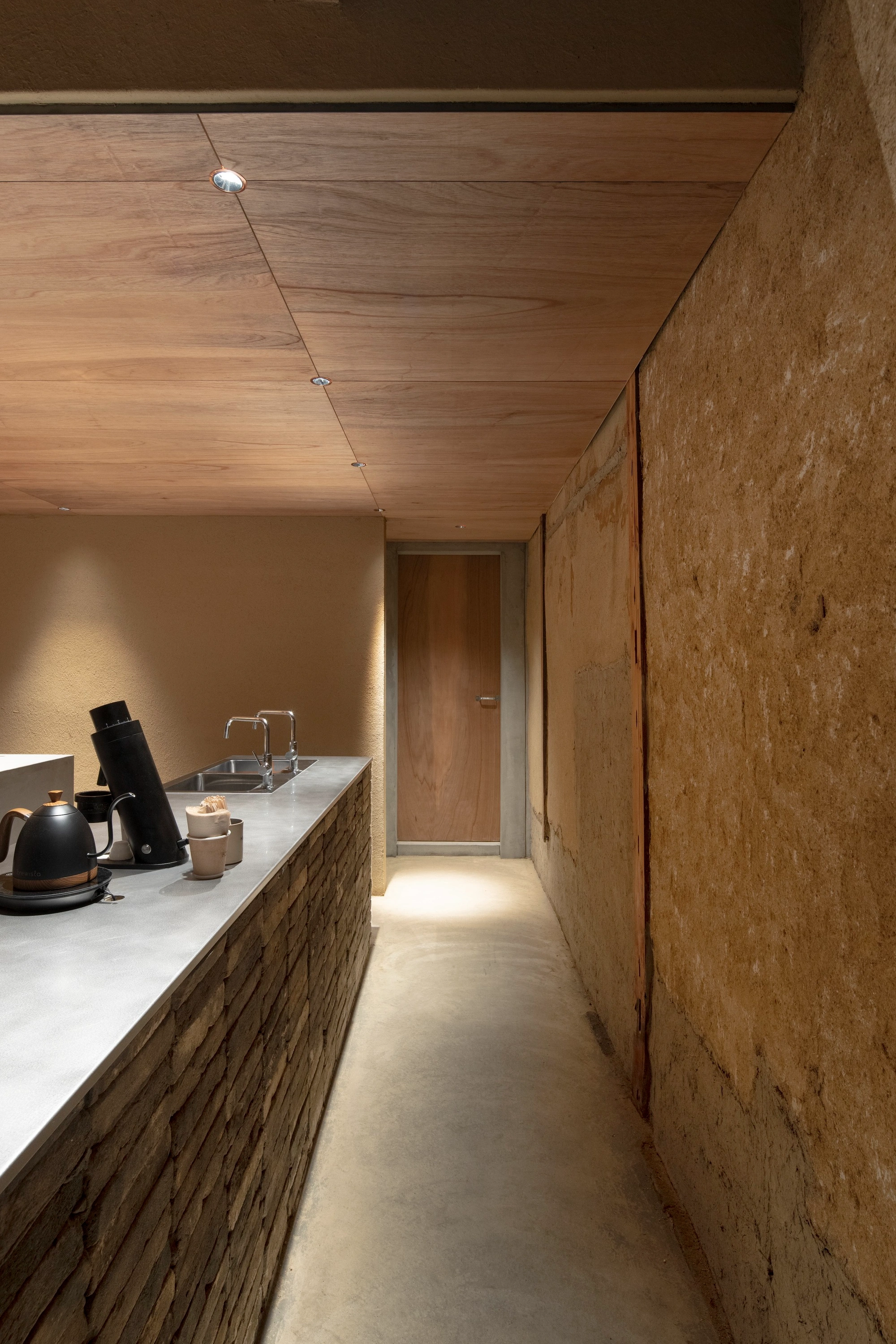 HOO Cafe Kyoto by Koyori Architects — A narrow galley kitchen in HOO Cafe Kyoto reveals the adaptive reuse strategy of Koyori Architects.