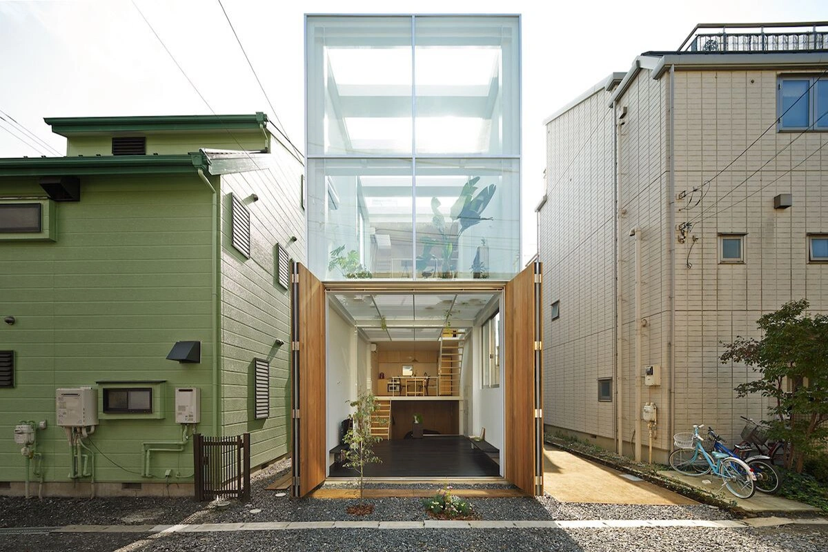 House in Kawasaki by Taichi Mitsuya & Associates — The House in Kawasaki presents itself as a glass and timber intervention compressed between neighboring brick and tile-clad structures.