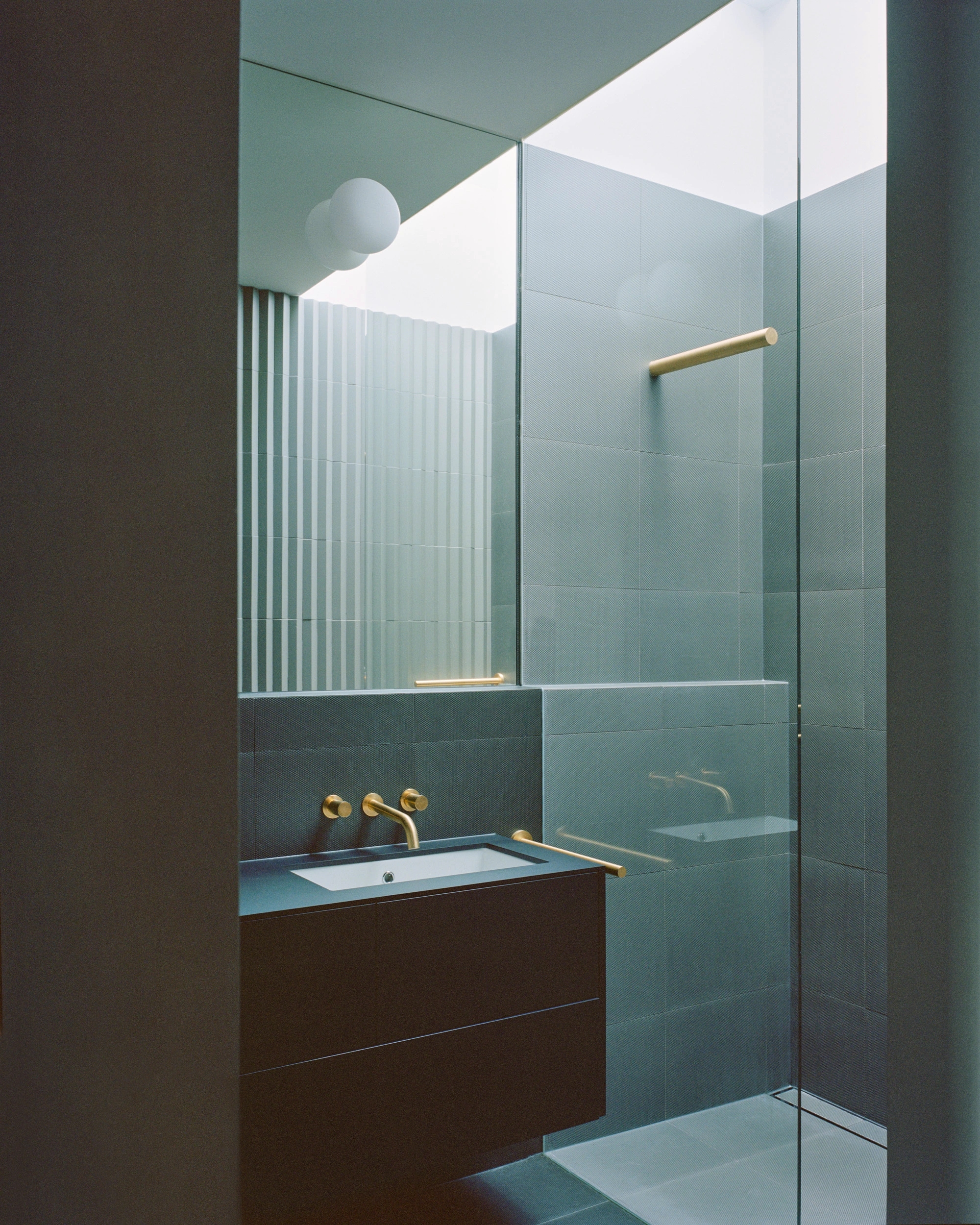House K by Kart Projects — A bathroom interior defined by geometric materiality and controlled chromatic contrast.