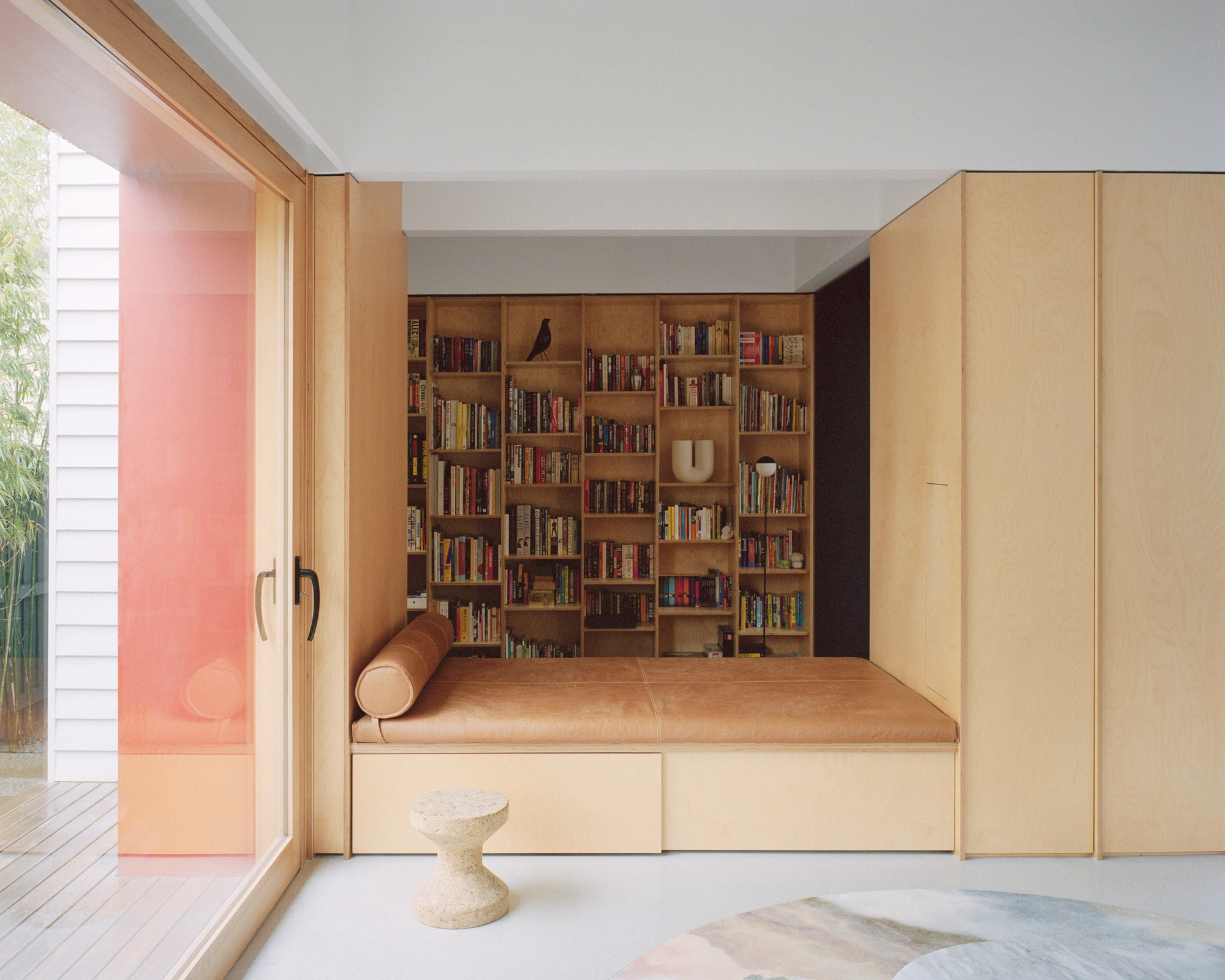 House K by Kart Projects — A timber-lined bedroom alcove integrates storage, seating, and library function within a compact 50 m² extension.