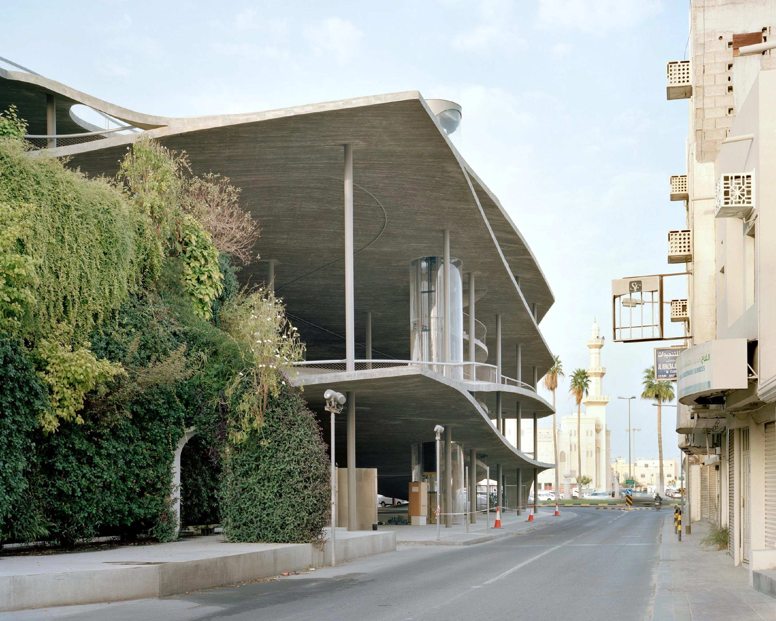 Pearling Path's Four Car Parks by Christian Kerez — A monolithic concrete structure with a dramatically pitched roof and curved cantilever dominates the street frontage in Muharraq's historic center.
