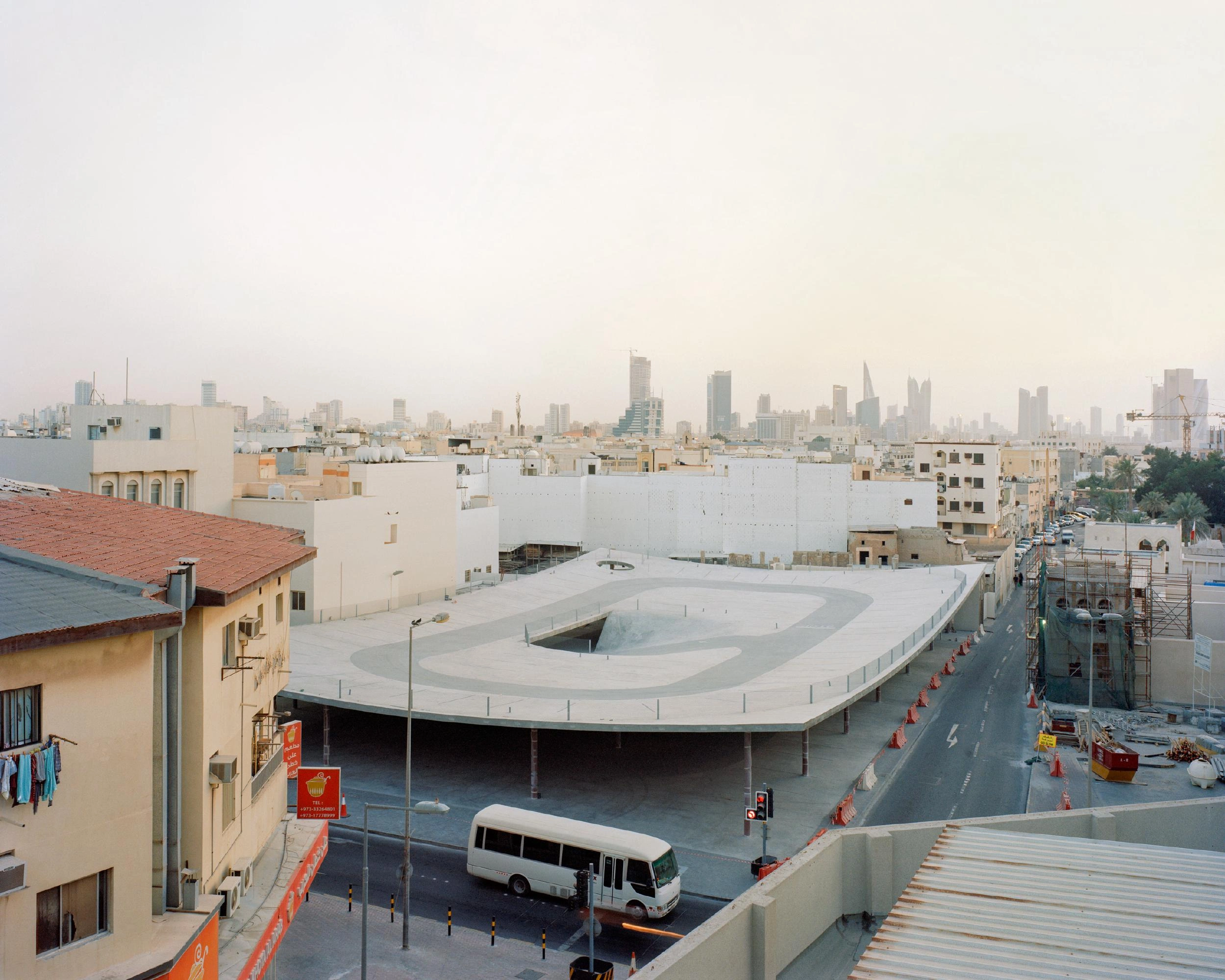 Pearling Path's Four Car Parks by Christian Kerez — Aerial view of the car park's pitched-roof structure dominates the medieval urban fabric of Muharraq.