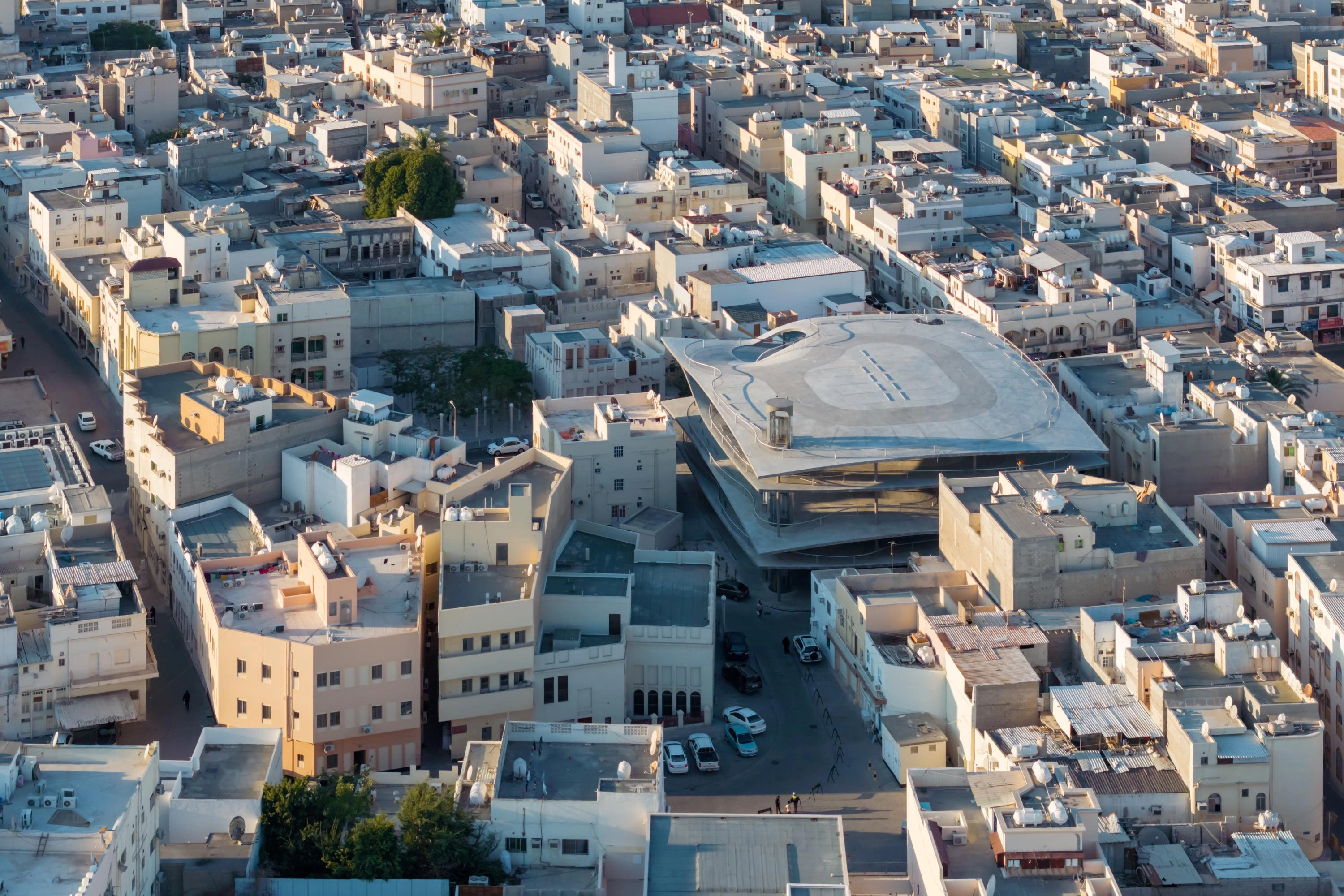 Pearling Path's Four Car Parks by Christian Kerez — Aerial view of Christian Kerez's car park structure embedded within Muharraq's dense medieval urban fabric.