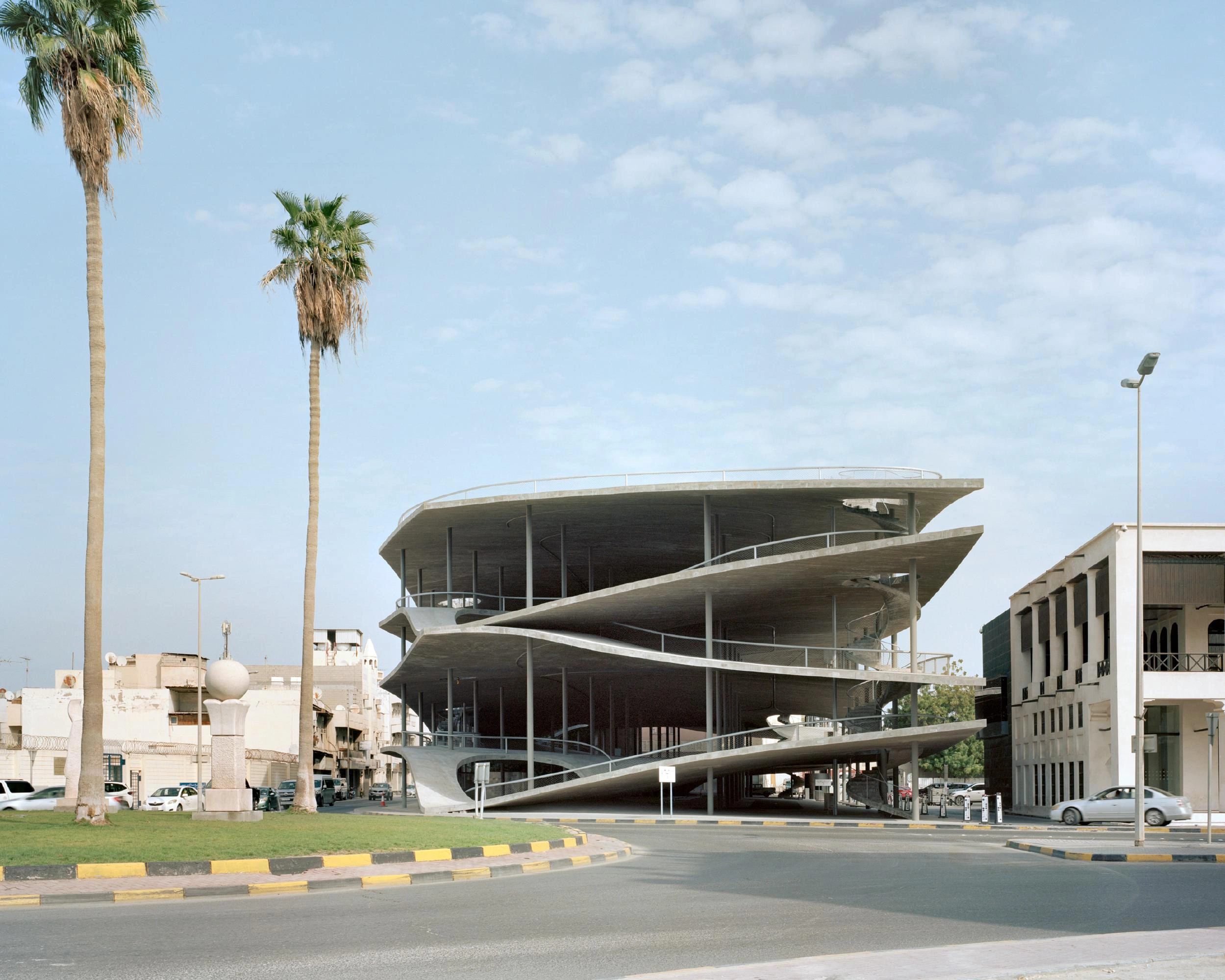 Pearling Path's Four Car Parks by Christian Kerez — Christian Kerez's spiraling concrete car park dominates Muharraq's streetscape with a pitched-roof form that cantilevers dramatically over the public threshold.
