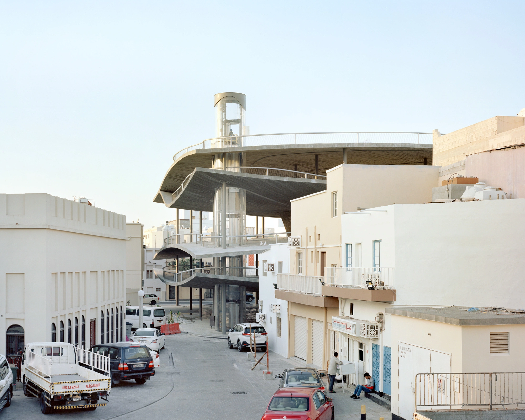 Pearling Path's Four Car Parks by Christian Kerez — A spiral ramp car park dominates the medieval street grid of Muharraq, its monolithic concrete form rising through multiple levels with dramatically...
