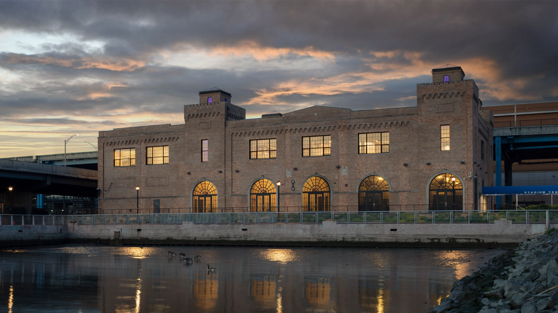 Bronx Children's Museum by O'Neill McVoy — The Bronx Terminal Market Powerhouse exterior at dusk, its load-bearing brick facade illuminated from within.