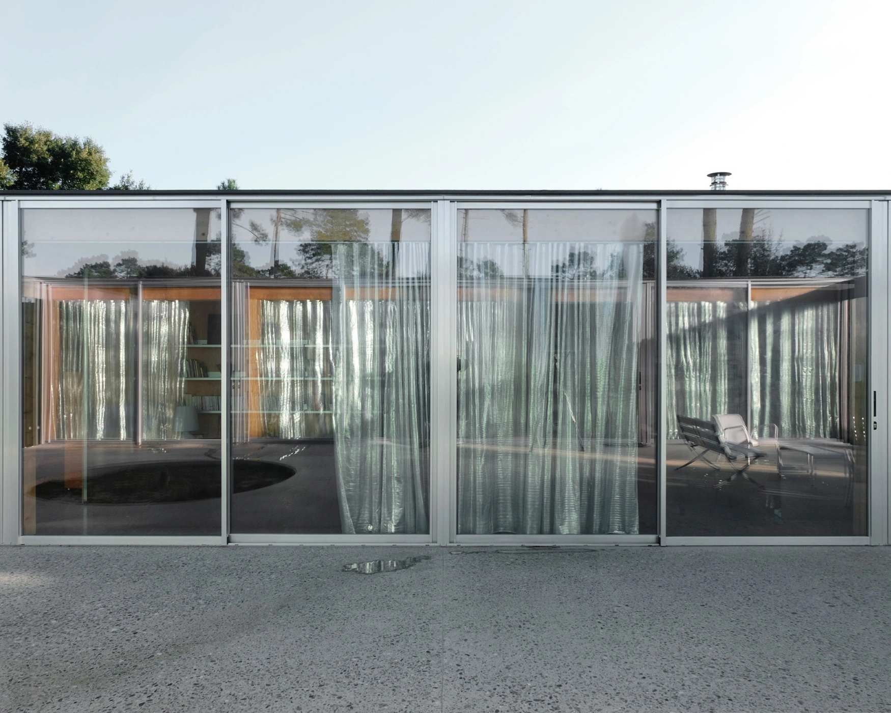 M37 House by BAST + littoral — The M37 House presents itself as a rectilinear glass volume with anodized aluminum mullions framing translucent panels that obscure interior activity while...