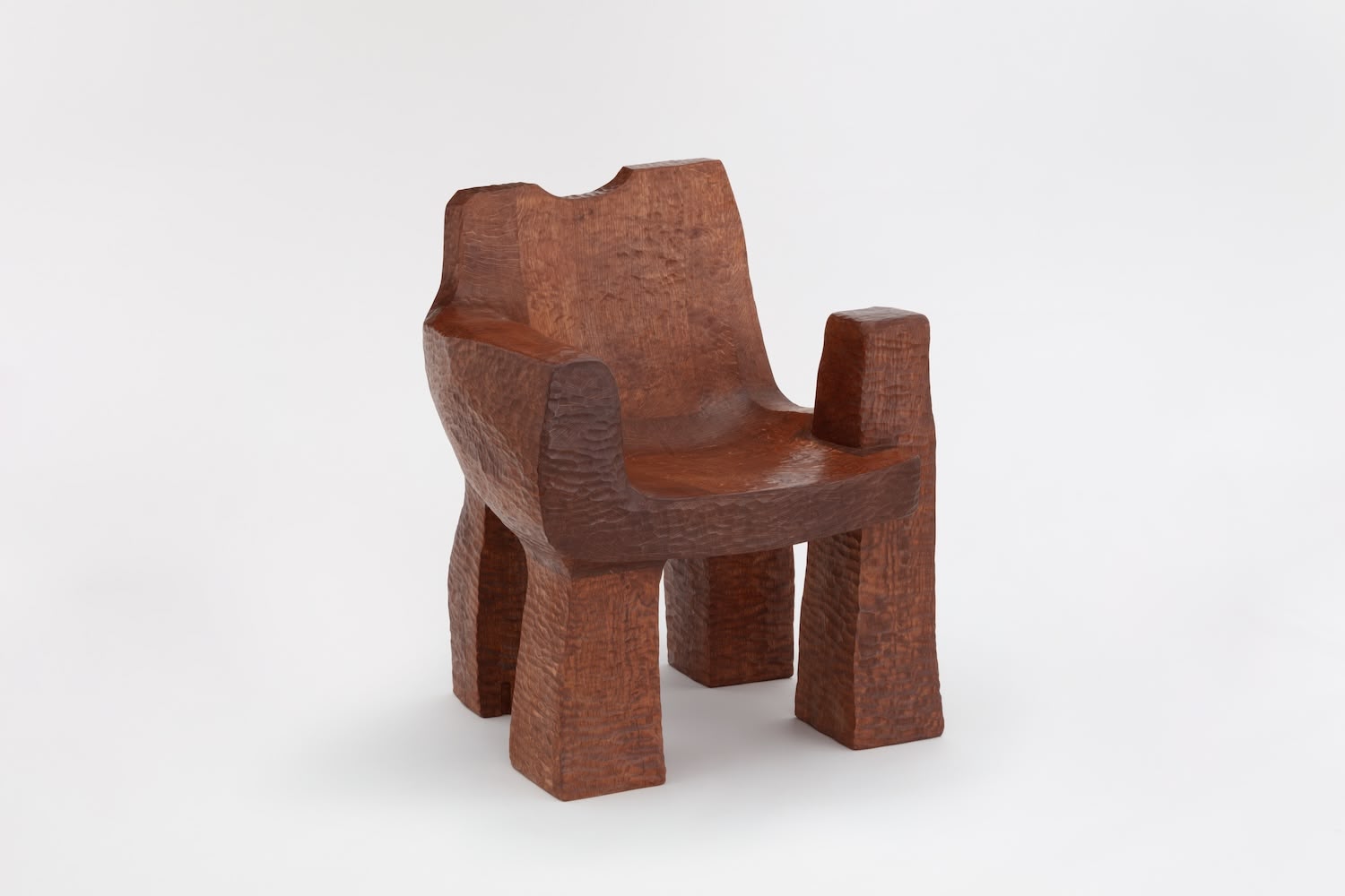 Cairn Chair by Faye Toogood — Carved from solid English oak, the Cairn Chair presents a monolithic form with four chunky rectangular legs supporting a deeply hollowed seat.