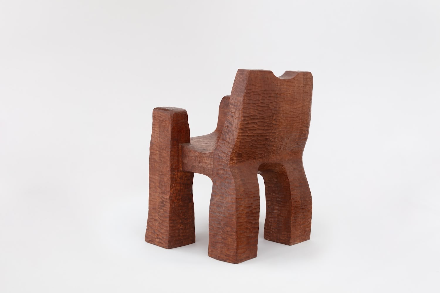 Cairn Chair by Faye Toogood — Carved from solid English oak, the Cairn Chair presents a monolithic form with four chunky rectangular legs anchoring a substantial base.