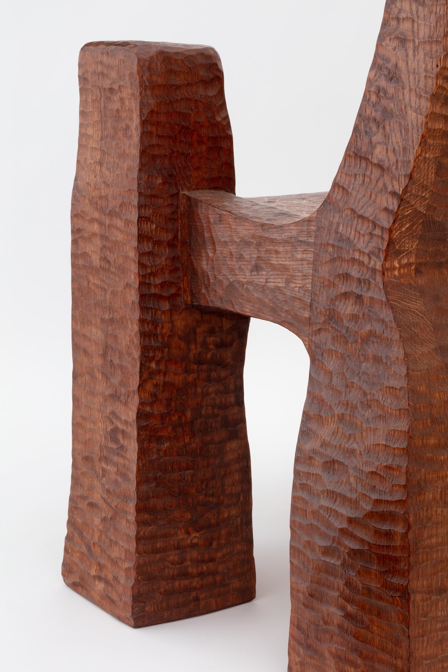Cairn Chair by Faye Toogood — Detail photograph capturing the joinery and carved surface of the Cairn Chair's backrest and seat interface.