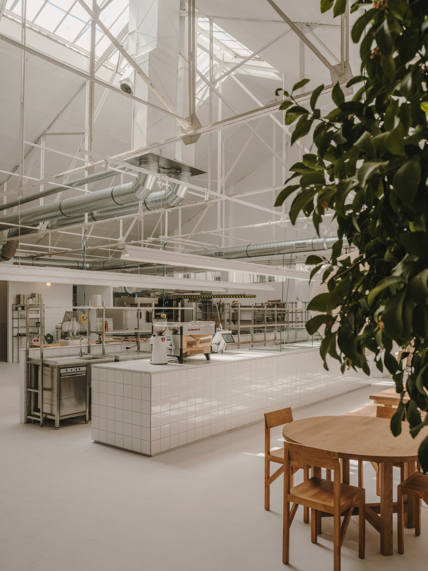 Alma Nomad by Plantea Studio by Plantea Estudio — A commercial kitchen and dining space unified by industrial materiality and precise spatial planning.