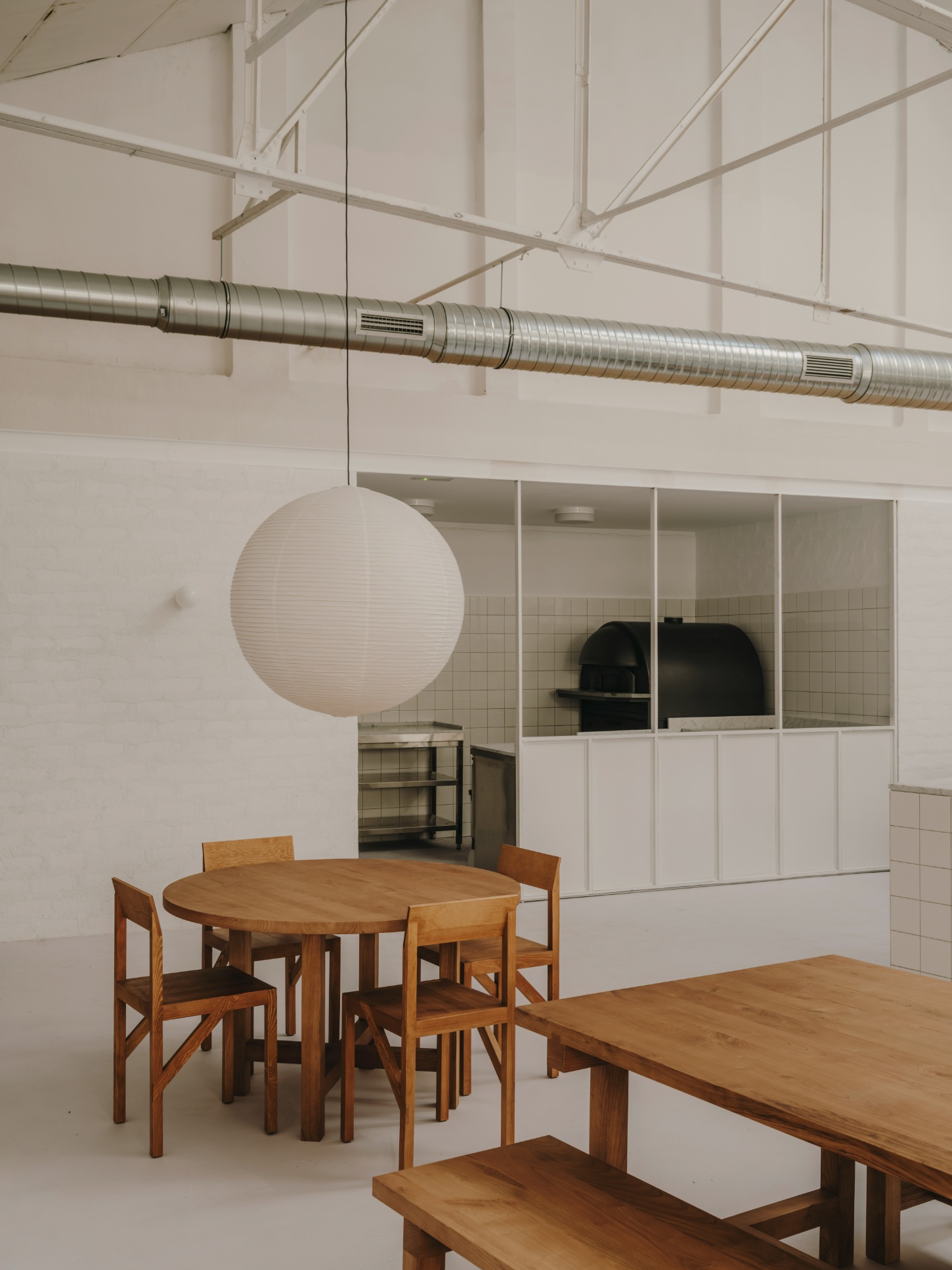 Alma Nomad by Plantea Studio by Plantea Estudio — A dining area defined by material and spatial contrasts.