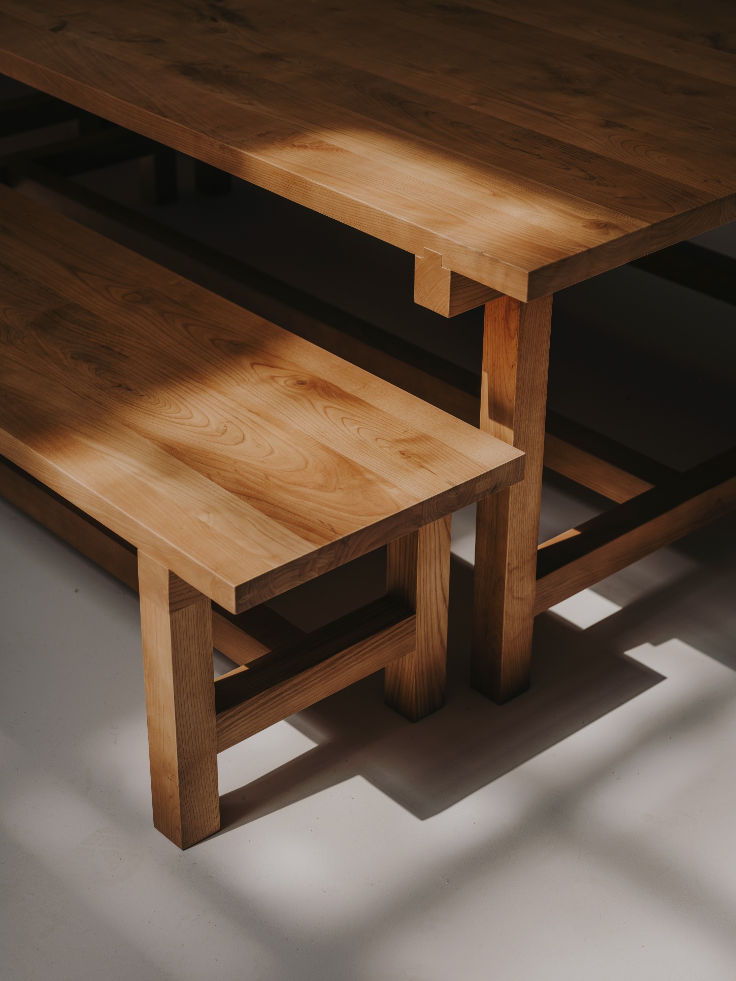 Alma Nomad by Plantea Studio by Plantea Estudio — A wooden dining ensemble photographed in raking light that emphasizes the materiality of the joinery.