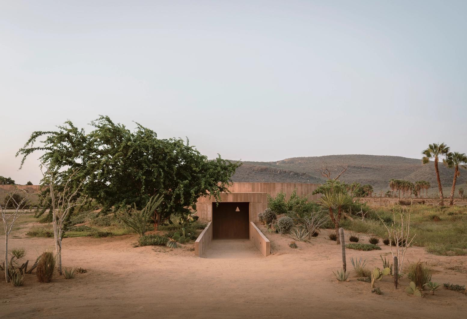 Spiritual Enclosure by Ruben Valdez — A monolithic concrete structure anchors the Baja California Desert landscape, its symmetrical twin walls framing a central aperture that captures the...
