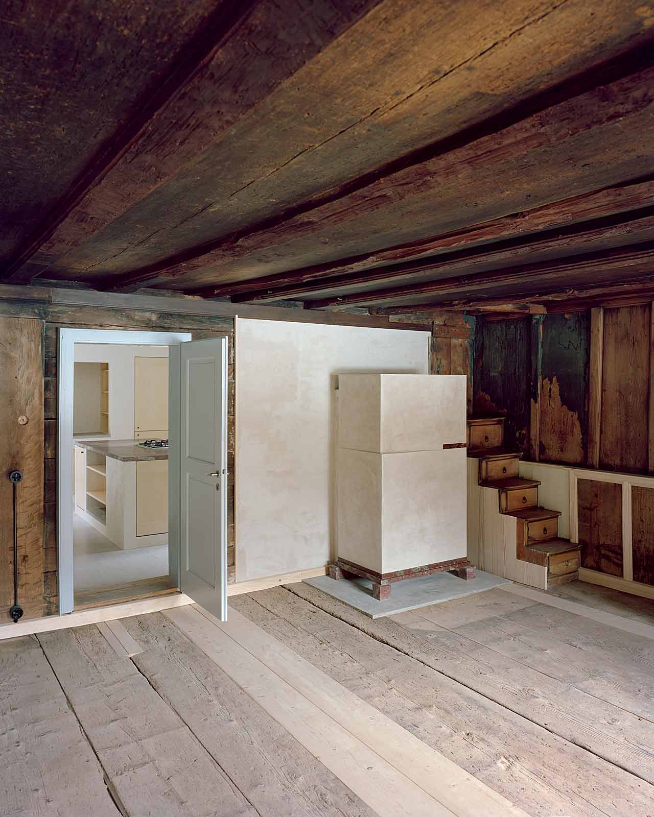 Mühle Ennenda by Atelier Lando Rossmaier — The interior of Mühle Ennenda reveals its layered construction history through exposed timber ceiling beams positioned above deteriorated original...