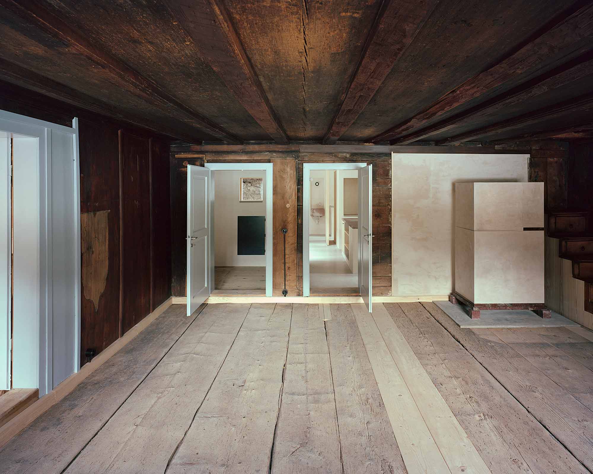 Mühle Ennenda by Atelier Lando Rossmaier — A timber-beamed interior reveals layers of architectural intervention within the historic Mühle Ennenda.
