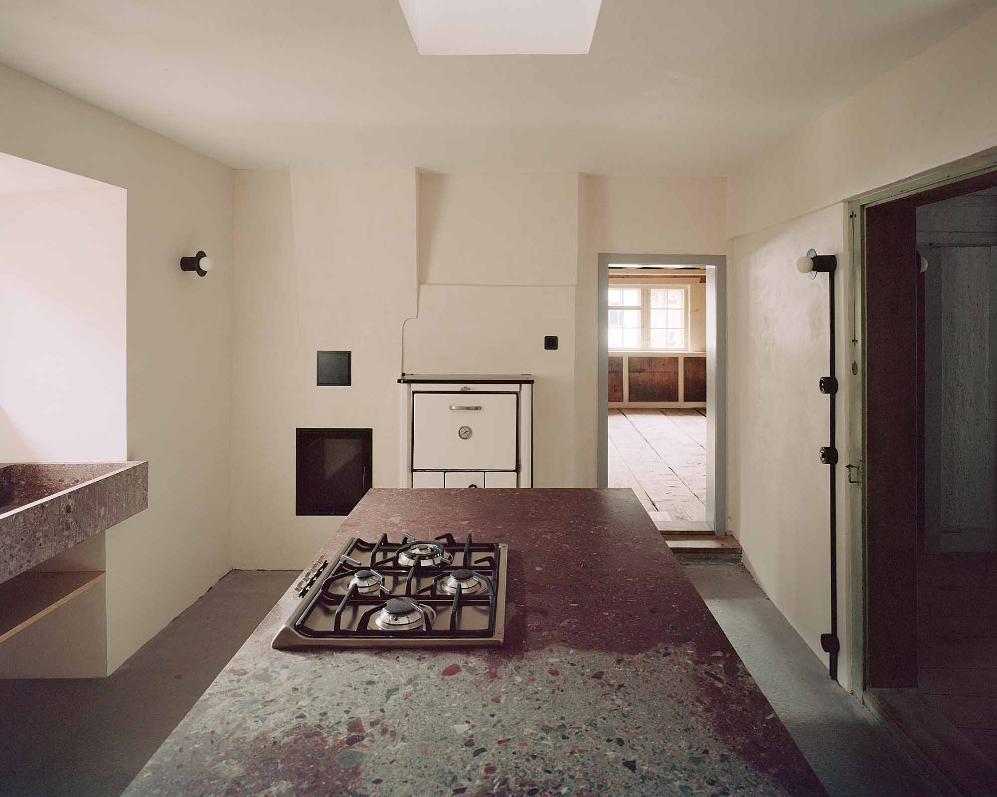 Mühle Ennenda by Atelier Lando Rossmaier — The kitchen interior reveals the project's archaeological approach through layered materiality.