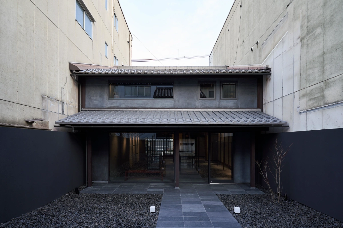 Issey Miyake Kyoto by Naoto Fukasawa Design — A narrow courtyard passage frames the storefront's recessed entry, revealing the layered depth of Fukasawa's intervention.
