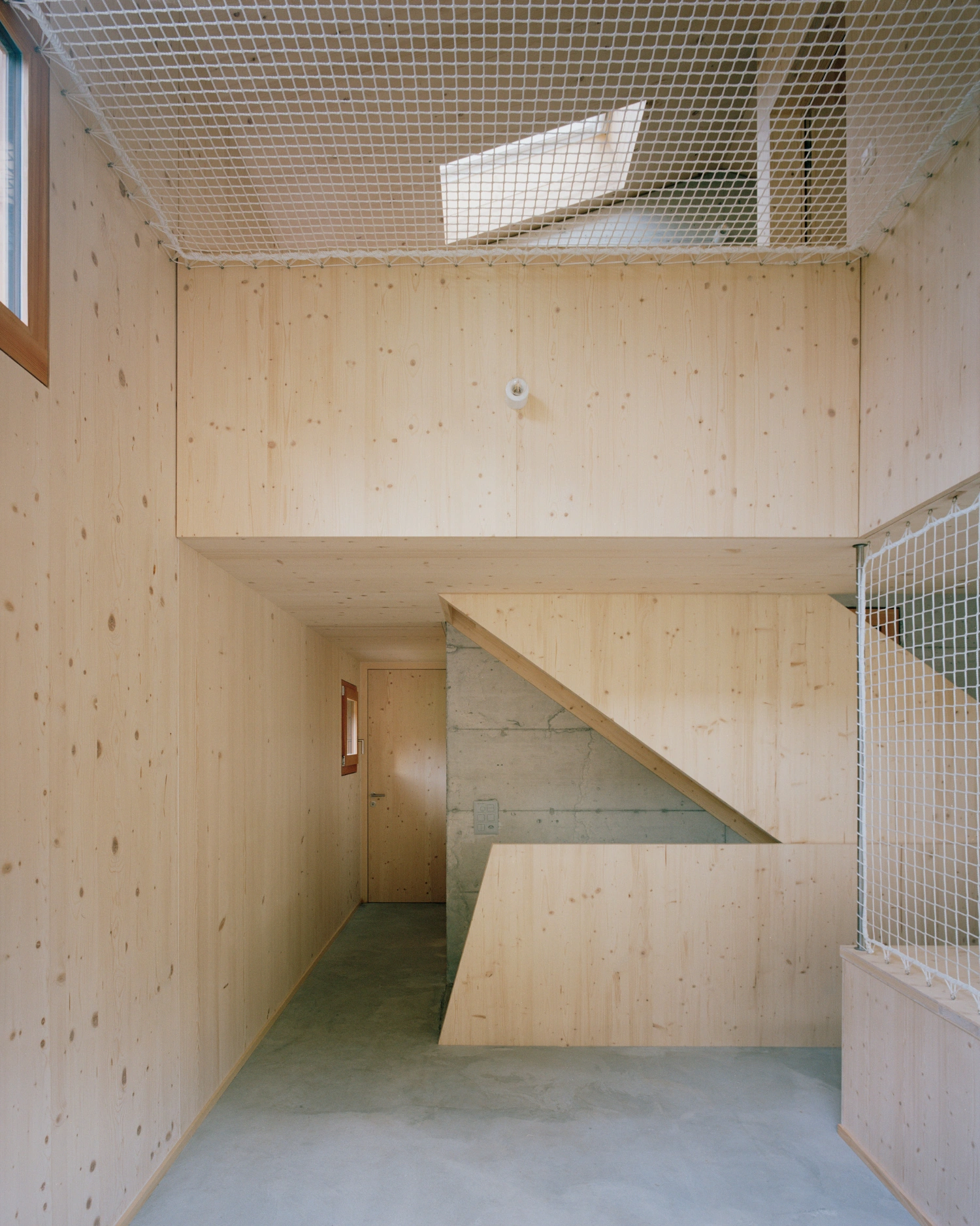 The Wandering House by Lionel Ballmer — Interior view of a multi-level timber construction with plywood wall and ceiling surfaces.