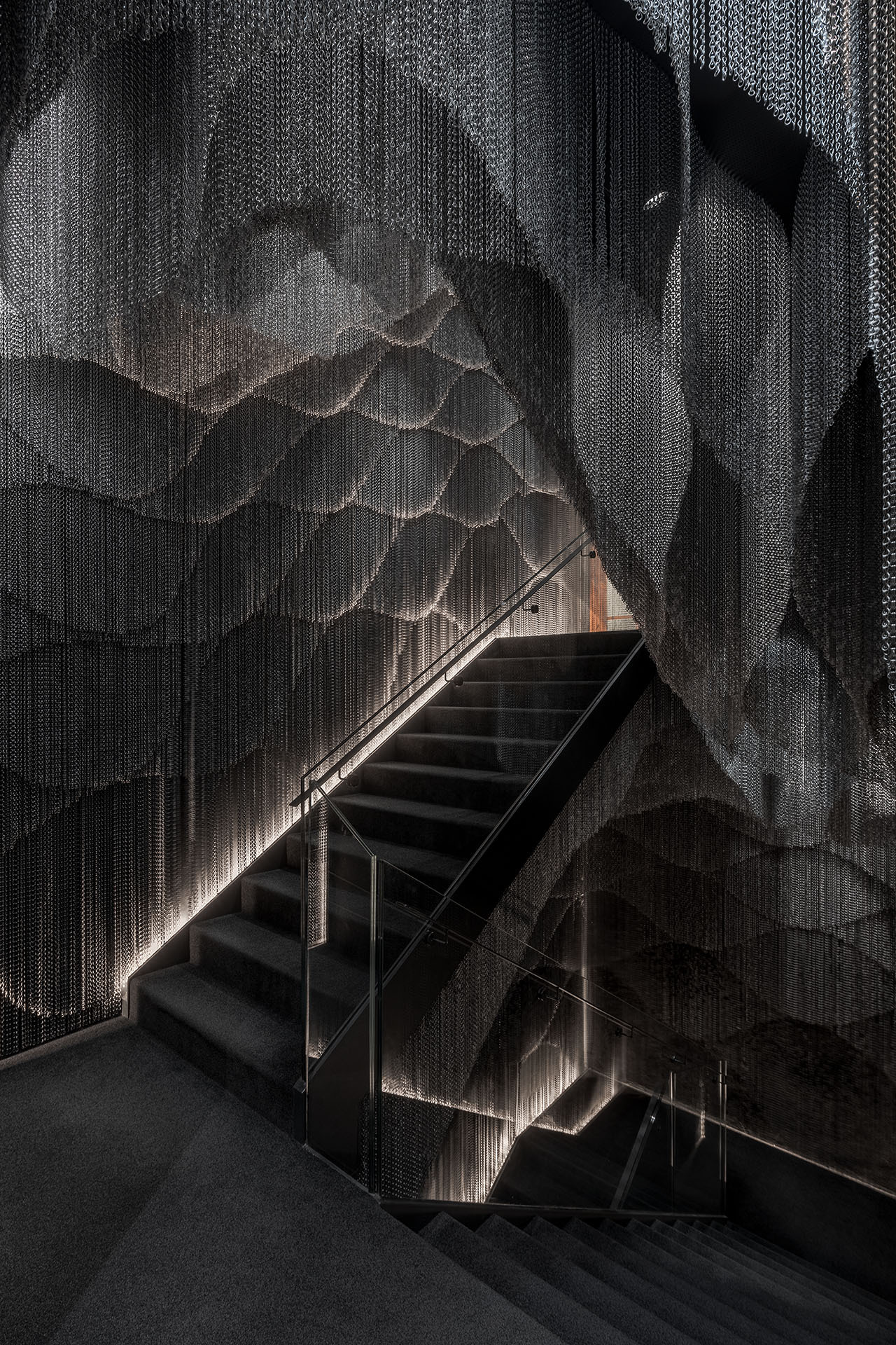 Casa Batlló Stairs & Atrium by Kengo Kuma — Kengo Kuma's intervention transforms Casa Batlló's central stairwell through cascading aluminum chain curtains that envelop both walls from floor to ceiling.