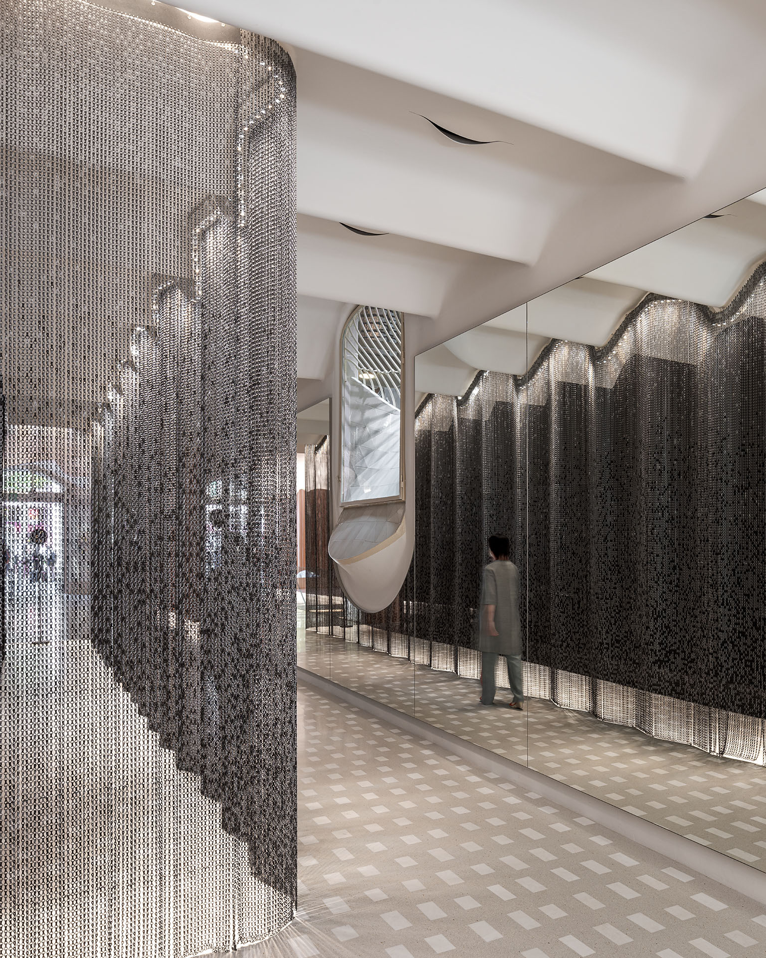 Casa Batlló Stairs & Atrium by Kengo Kuma — Kengo Kuma's intervention in Casa Batlló's stairwell employs cascading aluminum chain curtains that fragment and redirect overhead light across the...