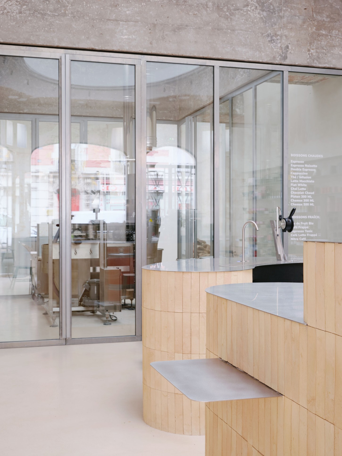 Anbassa by Office Abrami Rojas by Office Abrami Rojas (OAR) — A café interior featuring custom timber cabinetry with vertical slat cladding in light wood, organized in a sculptural, stepped configuration.