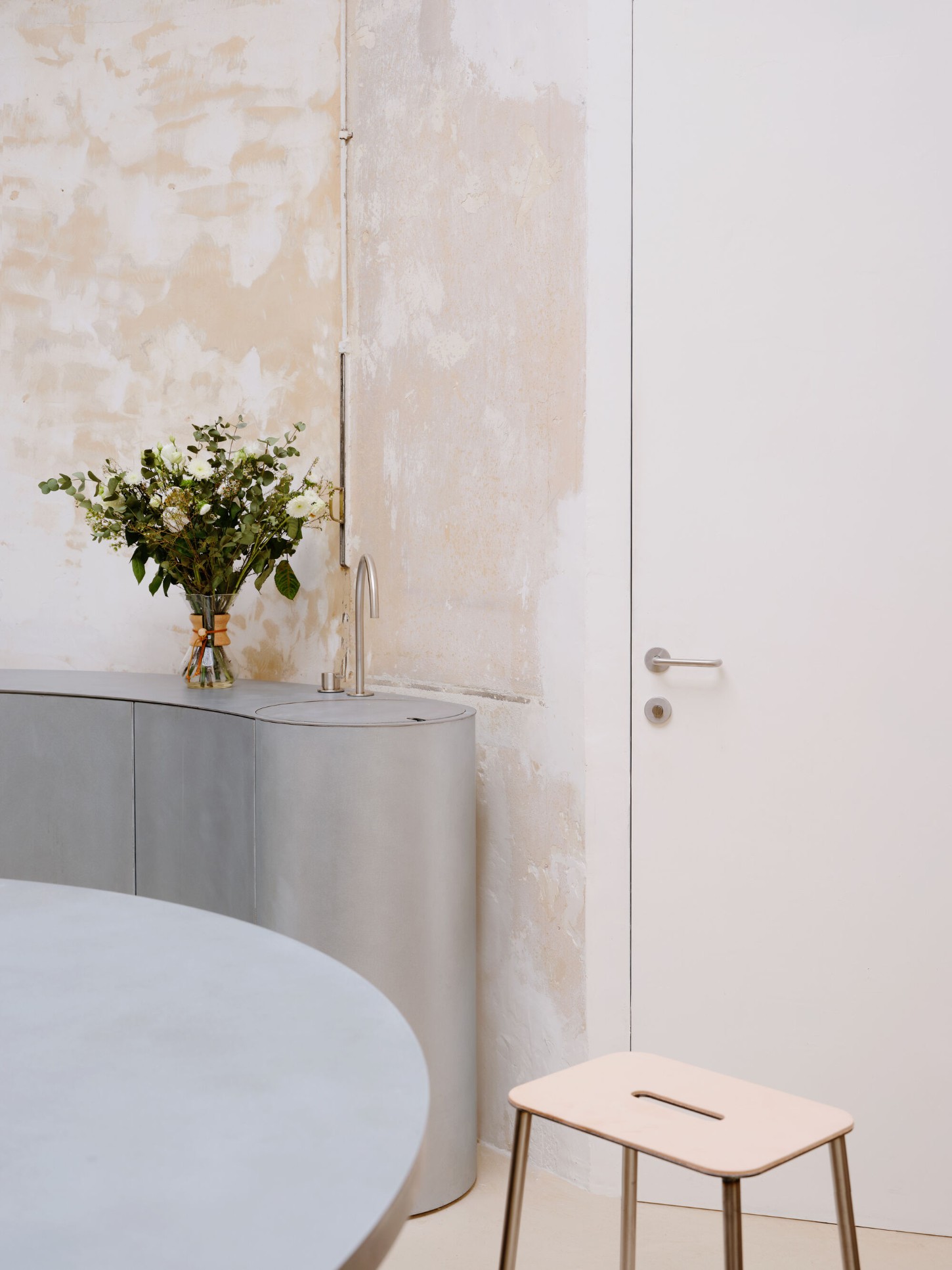 Anbassa by Office Abrami Rojas by Office Abrami Rojas (OAR) — A bathroom detail revealing the architectural strategy of Anbassa: a cylindrical concrete sink basin with integrated faucet sits atop timber cabinetry with...