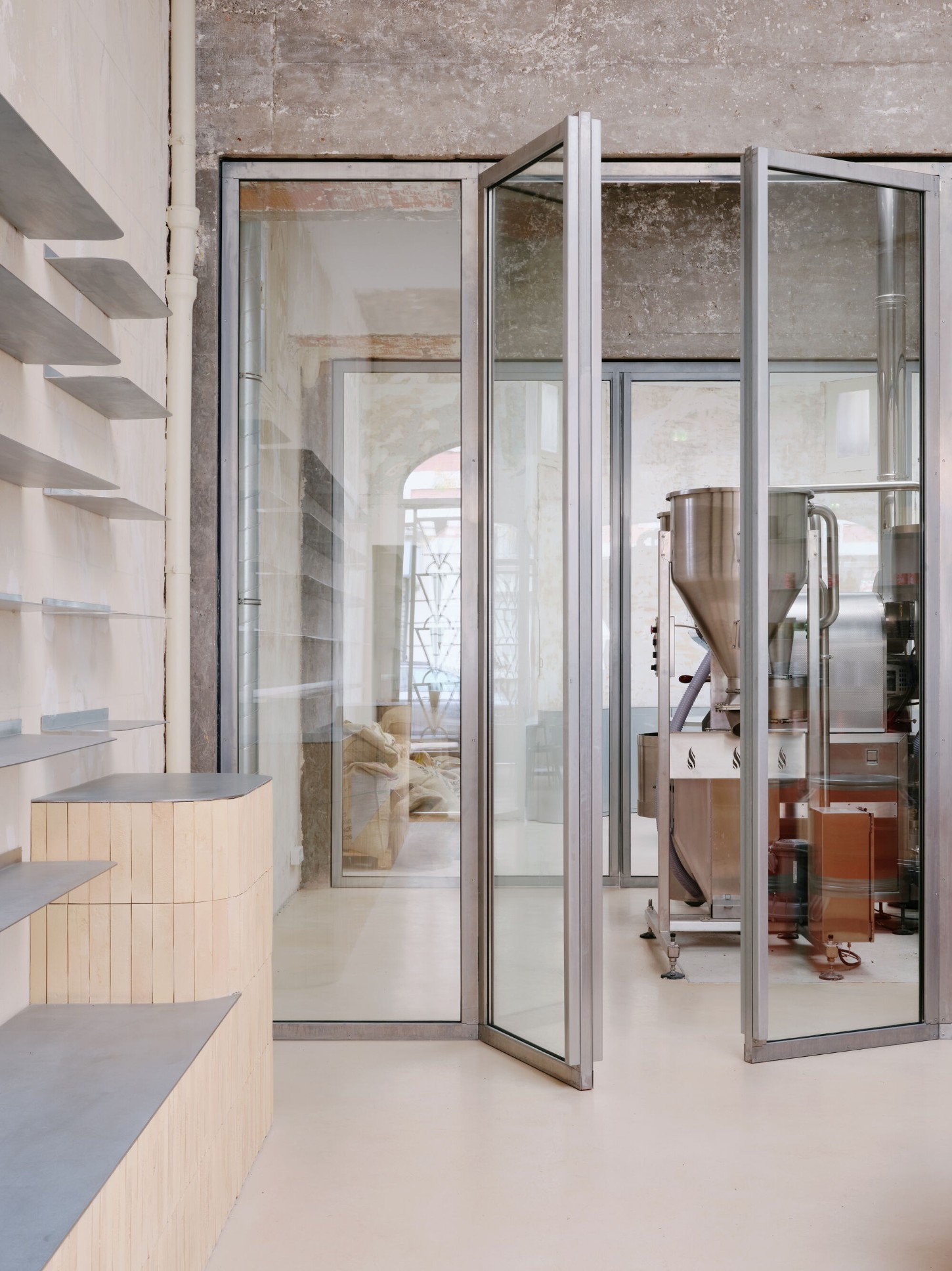 Anbassa by Office Abrami Rojas by Office Abrami Rojas (OAR) — A glass-partitioned workshop space reveals layered materiality and functional transparency.
