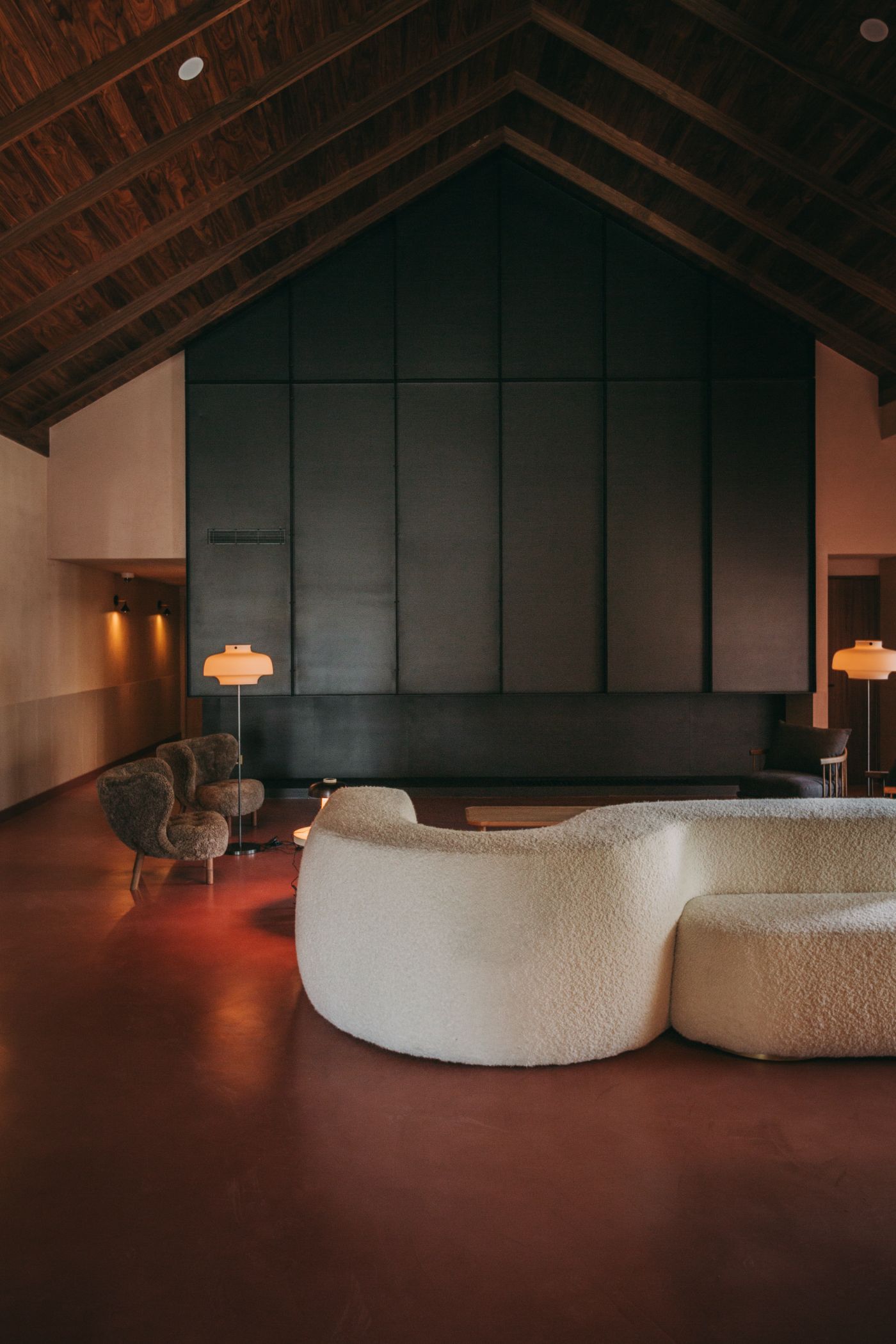 Torel Quinta da Vacaria in Douro Valley by Studio Astolfi and architect Luís Miguel Oliveira — A monumental interior volume defined by timber herringbone roof structure and floor-to-ceiling gridded window wall in dark steel frame.