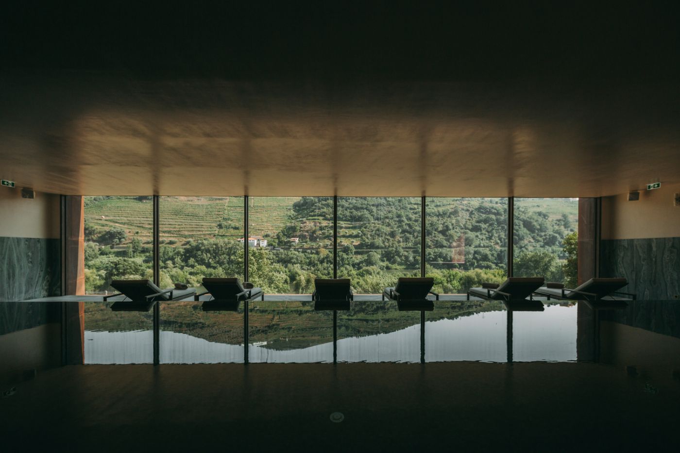 Torel Quinta da Vacaria in Douro Valley by Studio Astolfi and architect Luís Miguel Oliveira — A spa or wellness interior facing expansive Douro Valley views through six floor-to-ceiling gridded windows with dark aluminum frames.