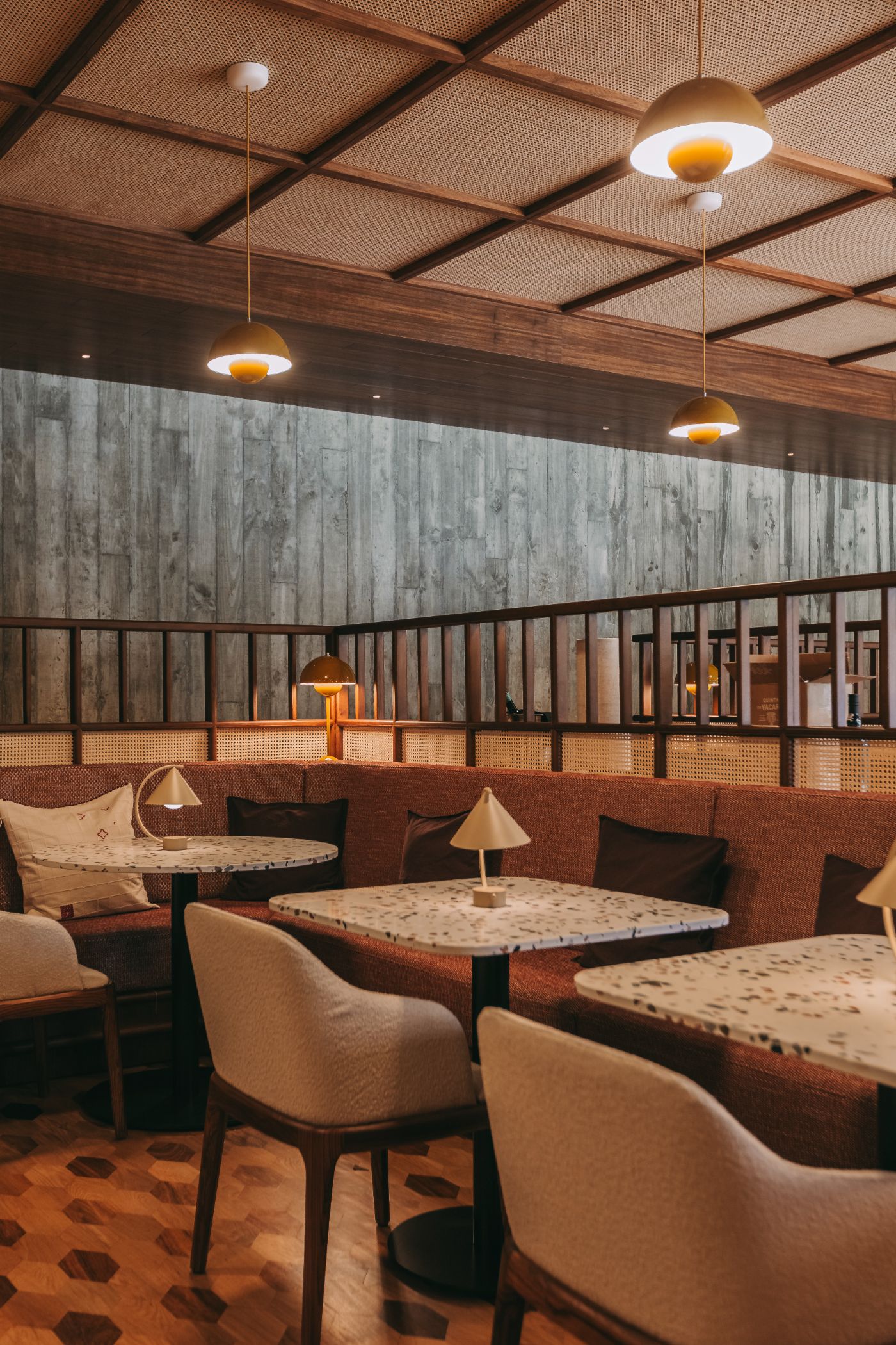 Torel Quinta da Vacaria in Douro Valley by Studio Astolfi and architect Luís Miguel Oliveira — The dining lounge showcases a layered material palette anchored by polished terracotta concrete flooring with geometric patterns.