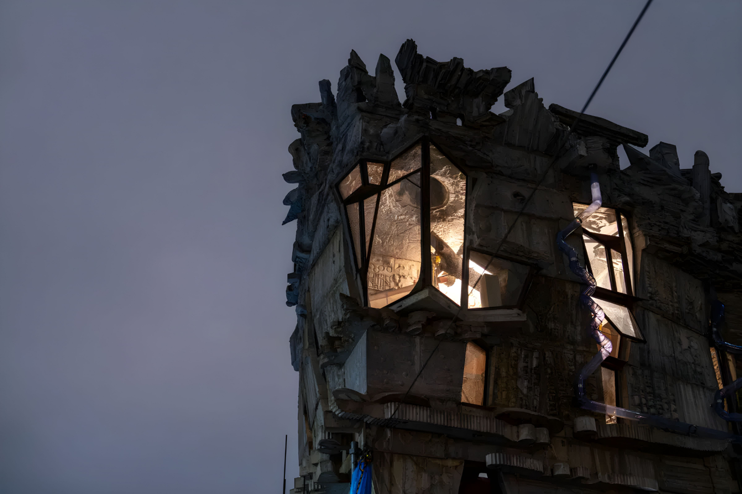 Arimaston Building by Keisuke Oka — Twilight photograph capturing the Arimaston Building's upper facade and sculptural crown against dimming sky.