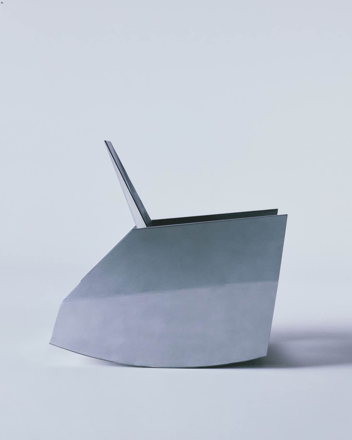 Godspeed by Waiting For Ideas — A sculptural chair photographed in profile against a neutral grey ground.