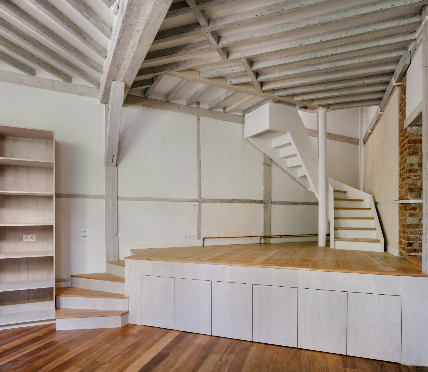 Atelier 22 by Atelier Mula Scala + Atelier Mas by Atelier Mura Scala and Atelier Mas — A double-height studio space in Montmartre reveals its original post-and-beam timber structure after 1970s alterations were removed.