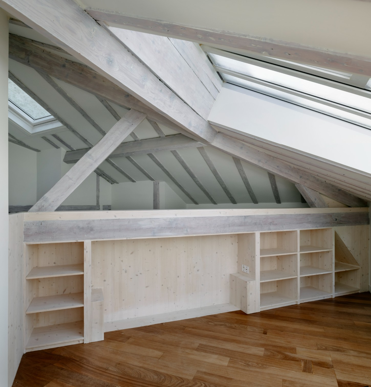 Atelier 22 by Atelier Mula Scala + Atelier Mas by Atelier Mura Scala and Atelier Mas — Attic studio space with exposed timber beam structure in pale finish creating geometric divisions overhead.
