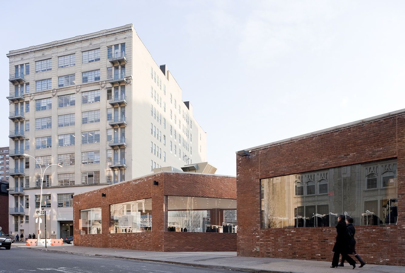 Yohji Yamamoto NYC Store by Junya Ishigami — The Yohji Yamamoto store's brick facade dominates the foreground, its weathered terracotta surface displaying uneven color and patina from exposure.