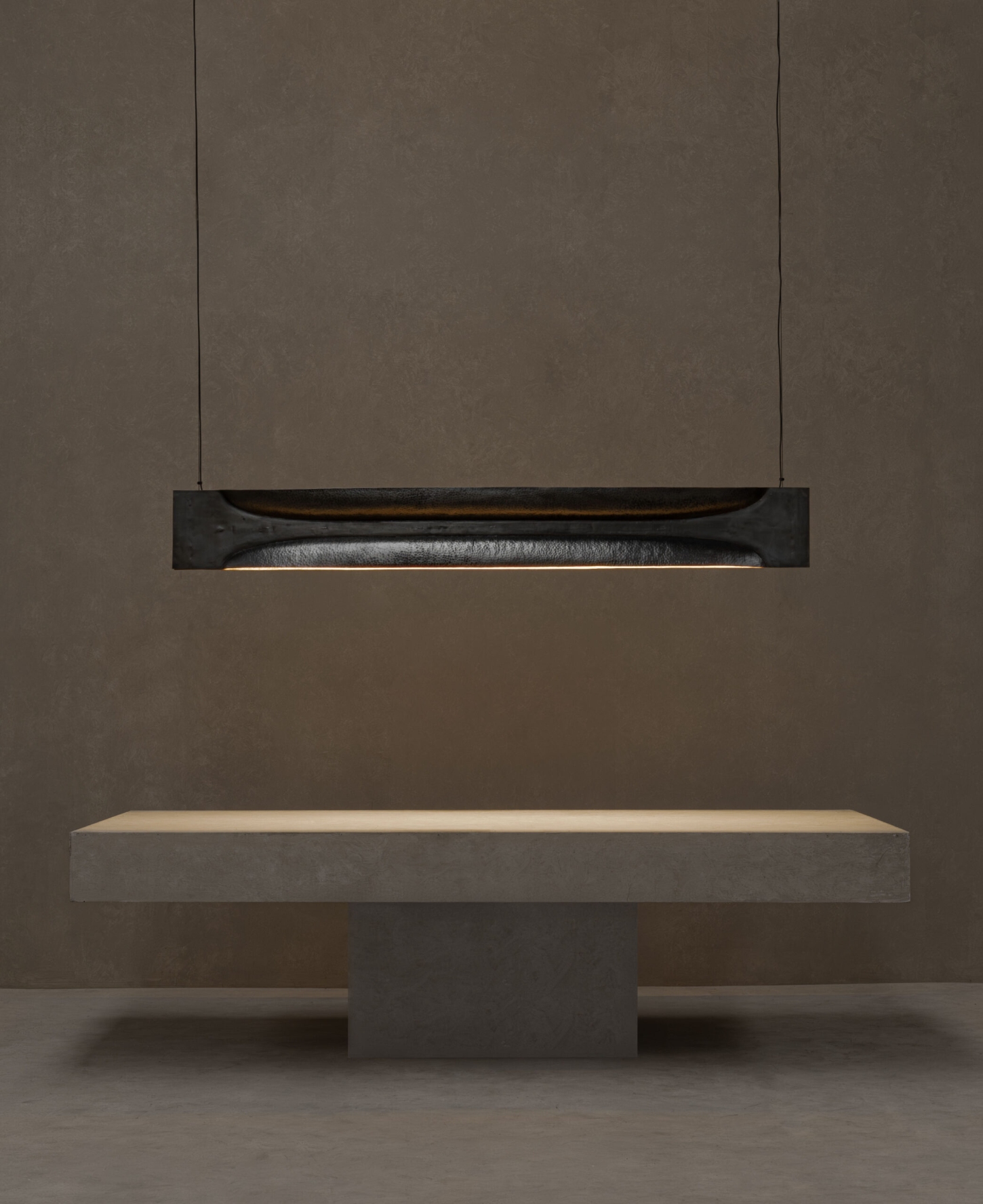 New Works by Manu Bañó — A suspended pendant lamp with oxidized copper construction occupies the upper register of this staged interior.