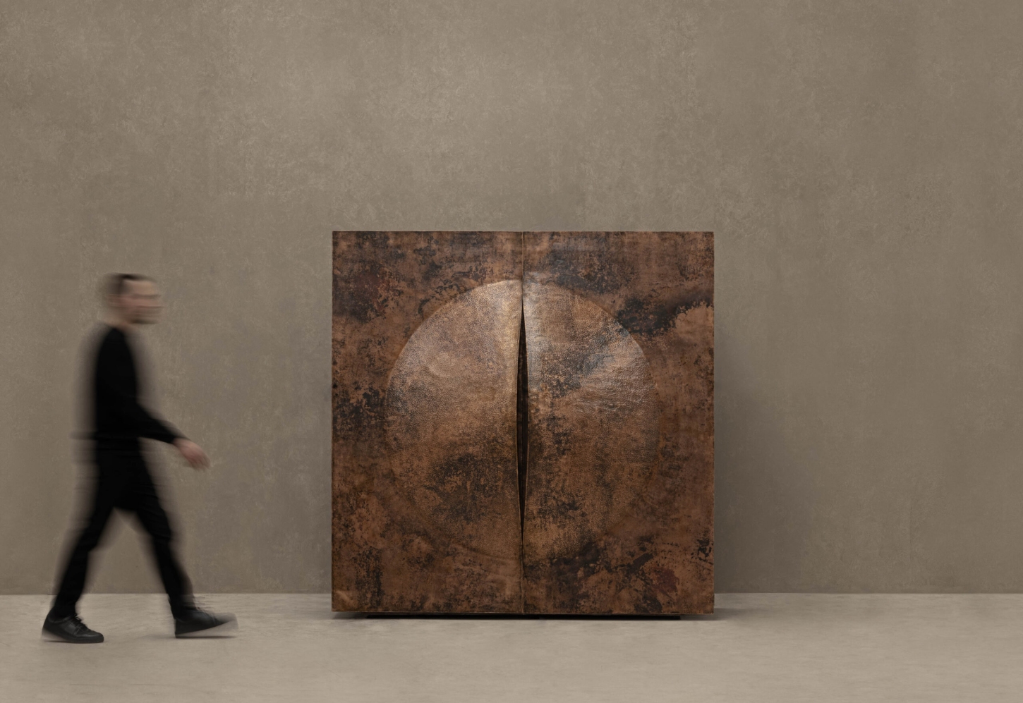 New Works by Manu Bañó — A fire-tempered copper object dominates the gallery floor, its surface divided by a vertical seam into two symmetrical halves.